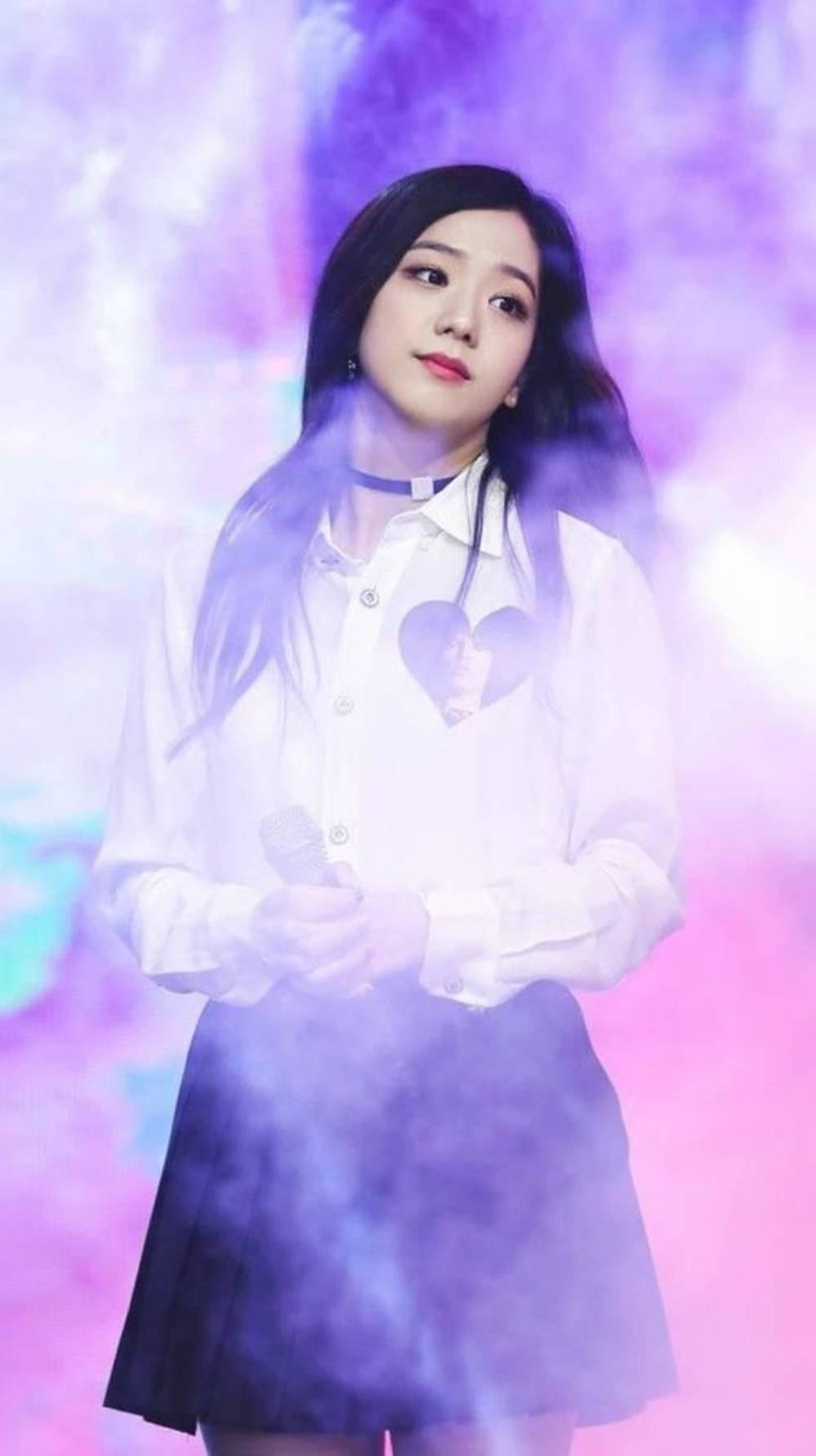 BLACKPINK 桌布 壁紙 — 一位身穿白襯衫和黑裙的年輕女子站在旋轉的紫色和粉紅色煙霧中，手持麥克風。