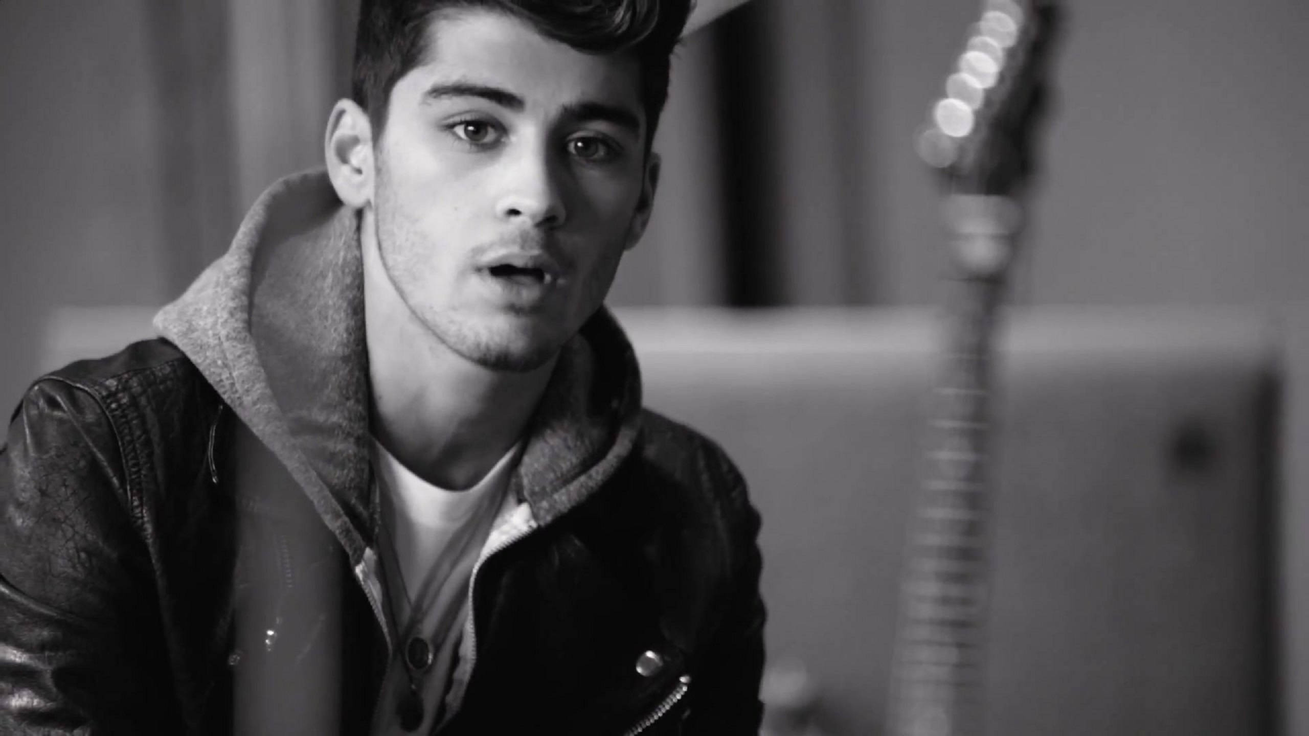 zayn 桌布 壁紙 — 一位身穿皮夾克的年輕男子專注地凝視，背景有一把模糊的吉他。