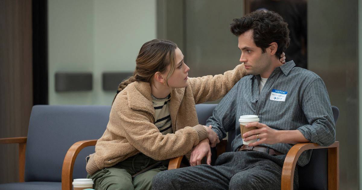 Netflix 桌布 壁紙 — 一位身穿米色外套的女性輕輕觸碰一位男士的肩膀，他們緊靠著坐在現代化等候室的藍色椅子上。