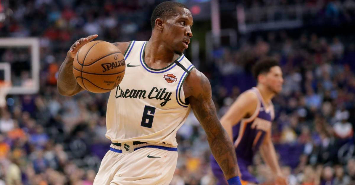 eric bledsoe 桌布 壁紙 — 一位身穿米色球衣的籃球運動員在比賽中激烈運球，背景是模糊的人群。
