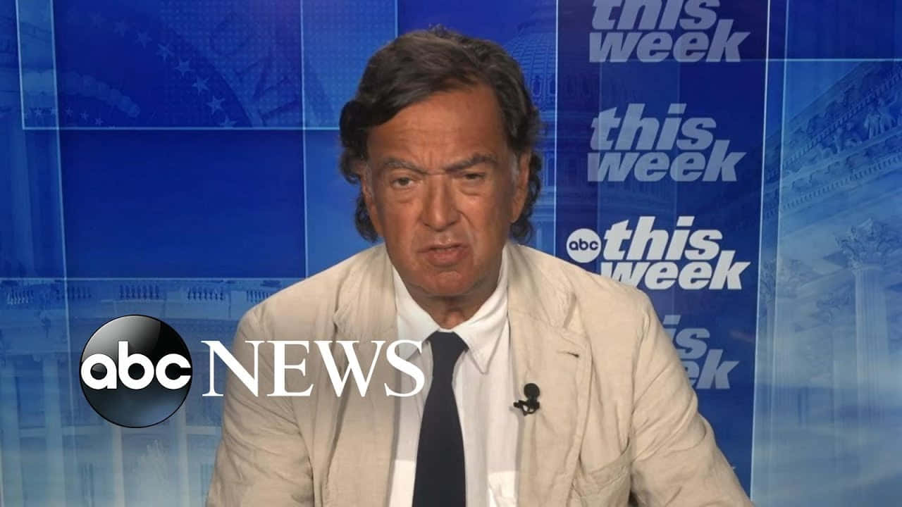 桌布 壁紙 — 一位身穿米色西裝、打黑色領帶的新聞主播，在藍色「This Week」ABC新聞工作室背景下專注地說話。