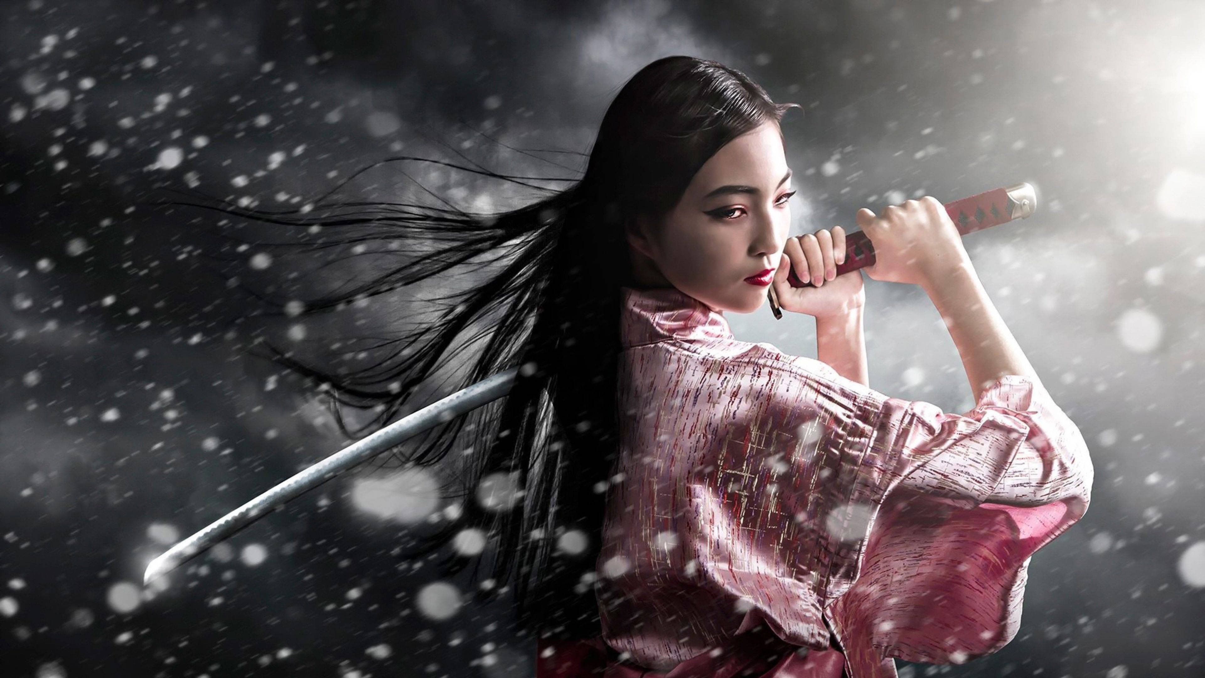 sword 桌布 壁紙 — 一位身穿粉紅色和服的優雅女武士，在戲劇性的暴風雪中手持武士刀，雪花在她周圍旋轉。