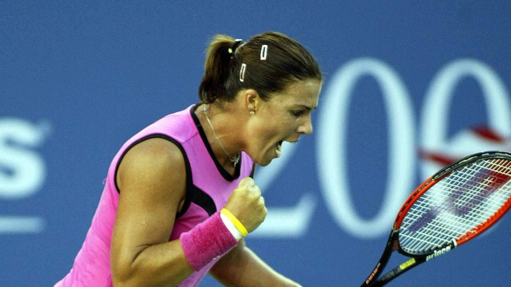 Jennifer Capriati 桌布 壁紙 — 一位身穿粉紅色服裝的女網球運動員握緊拳頭，高舉球拍，發出勝利的咆哮。