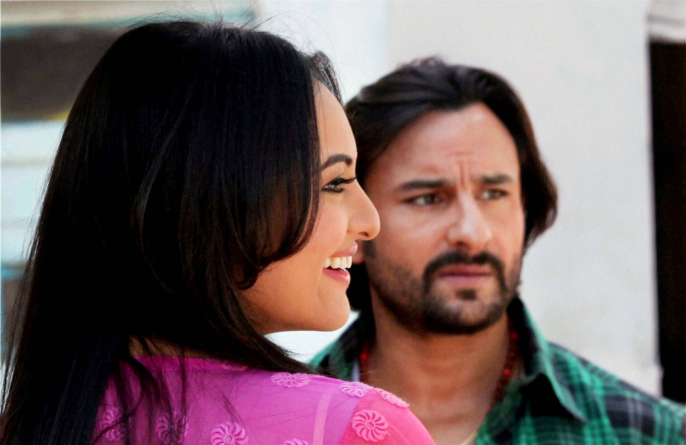 Saif Ali Khan 桌布 壁紙 — 一位身穿粉紅色花卉上衣的女性開懷大笑，而一位留鬍鬚的男性則帶著擔憂的表情看著。