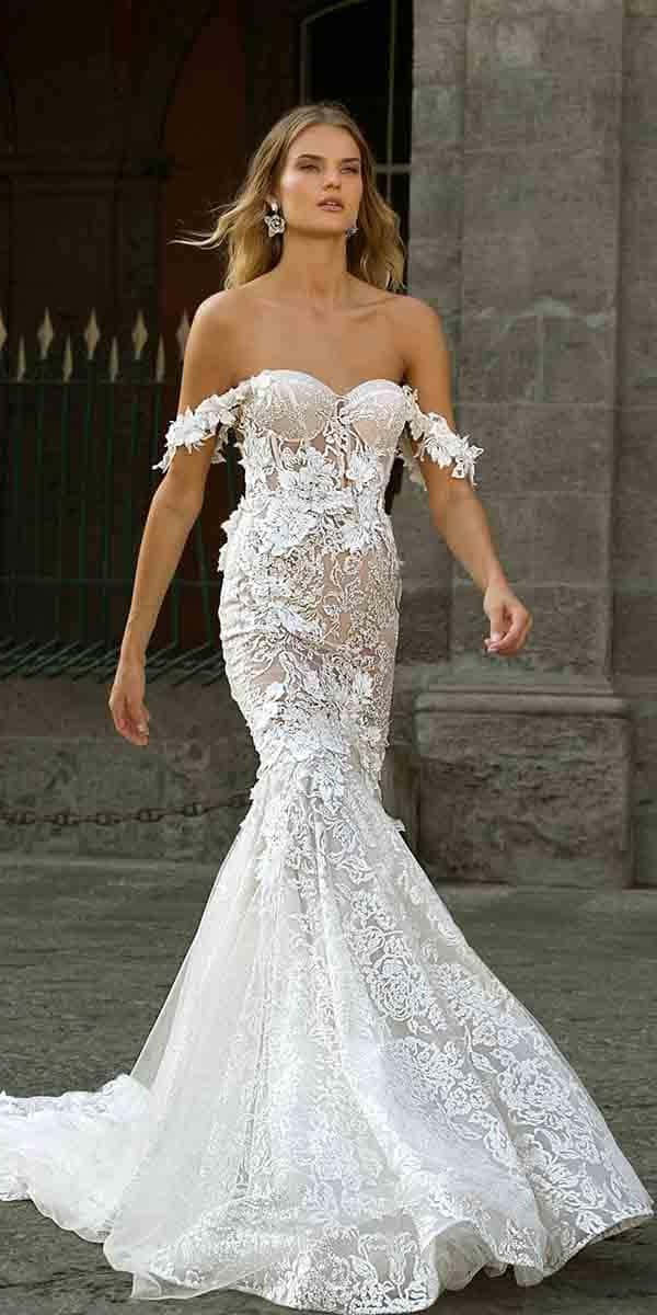 Wedding Gown 桌布 壁紙 — 一位身穿精緻白色蕾絲美人魚婚紗的女性，優雅地站在一座帶有華麗鐵藝的石造建築前。