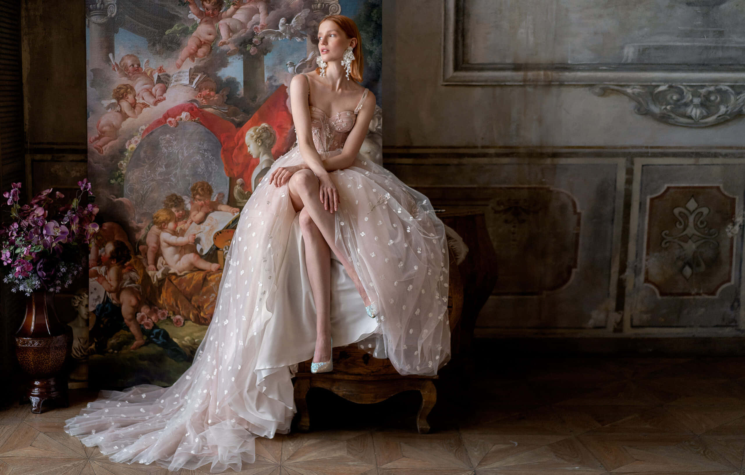 Bride's Dress 桌布 壁紙 — 一位身穿精緻白色銀點長裙的女性，優雅地坐在一張華麗的木凳上，旁邊是一幅大型古典畫作。