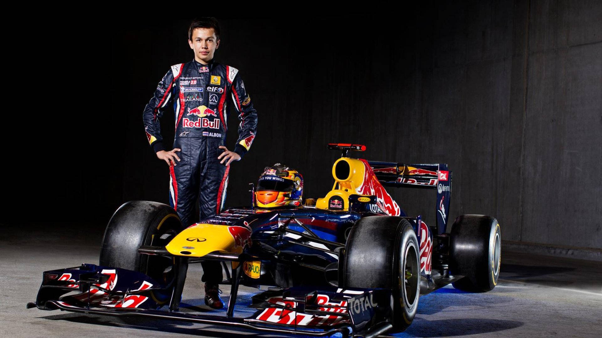 F1車手在黑暗的工作室環境中與他的紅牛賽車合影。 — 紅牛F1 壁紙