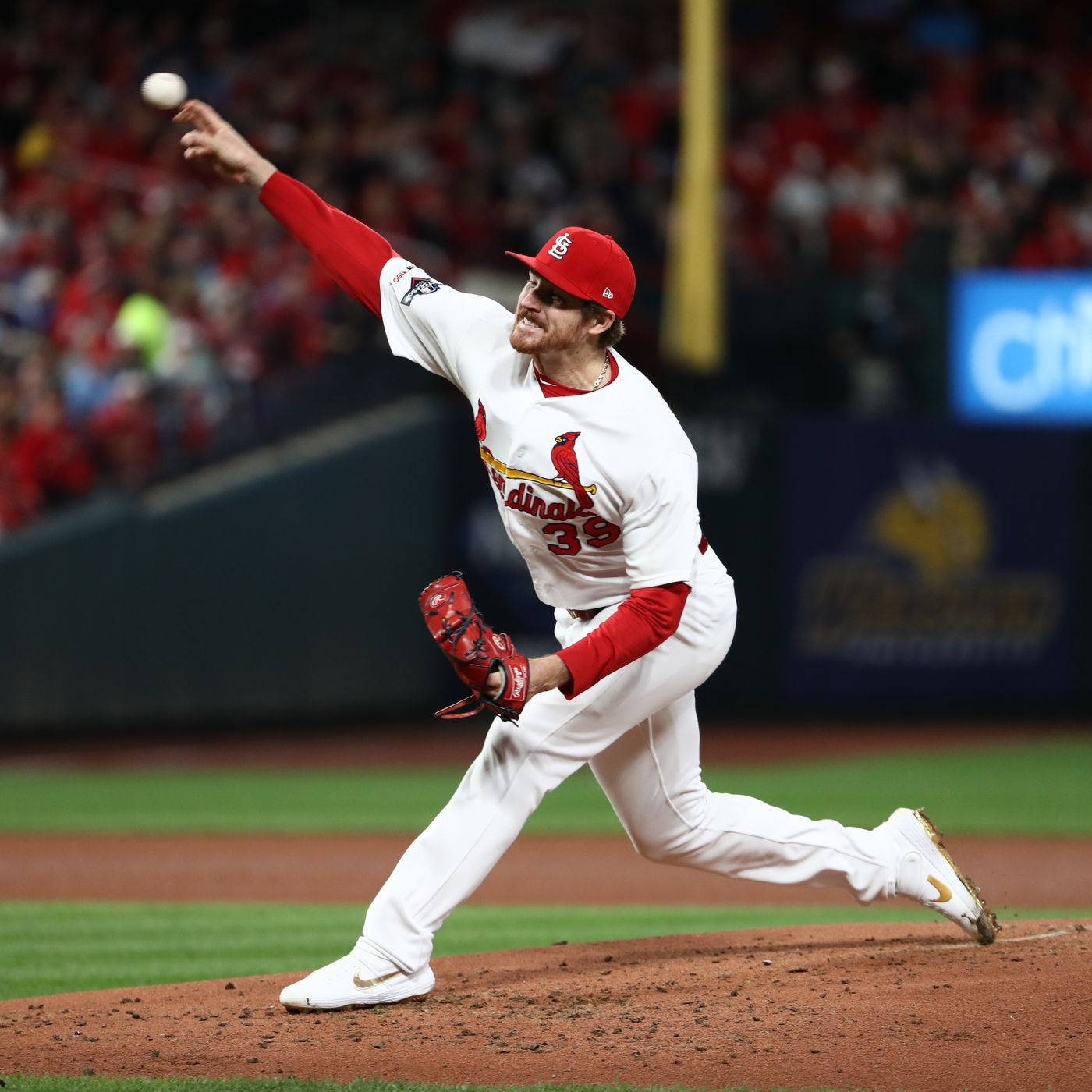 St Louis Cardinals 桌布 壁紙 — 一位身穿紅白卡迪納斯隊服的棒球投手，在燈光璀璨的球場投手丘上，專注地投出一球。