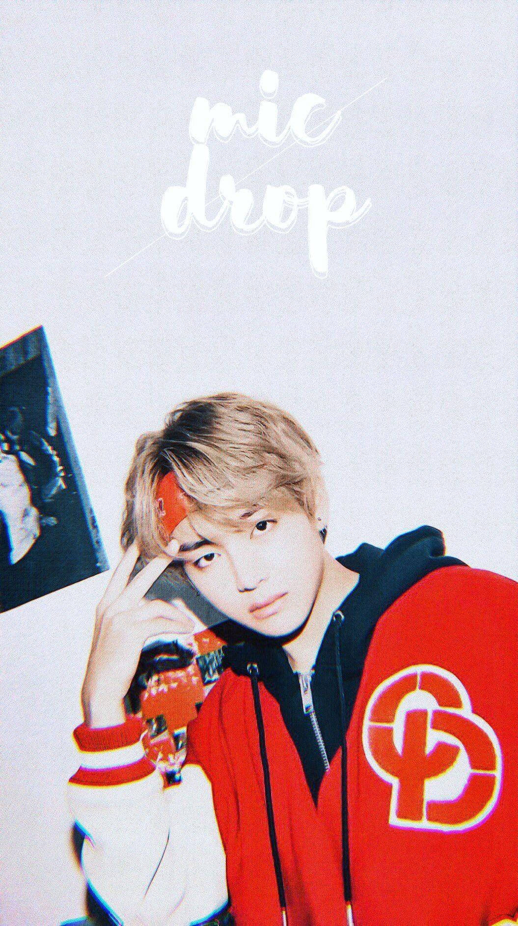 Taehyung Cute 桌布 壁紙 — 一位身穿紅白外套的年輕男子自信地拿著麥克風，在純色背景前擺姿勢，並帶有「mic drop」文字。