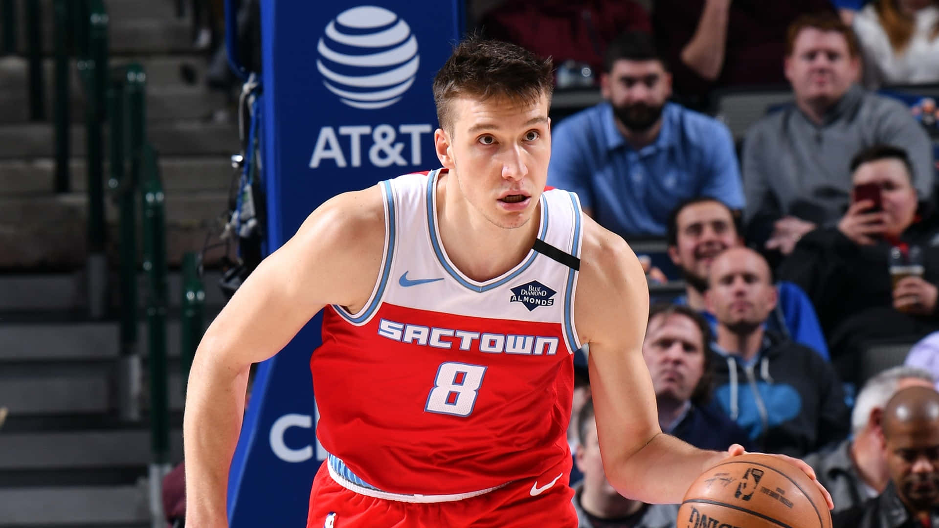 NBA 桌布 壁紙 — 一位身穿紅色 'Sactown' 球衣的專注籃球運動員，在觀眾背景下的激烈比賽中運球。