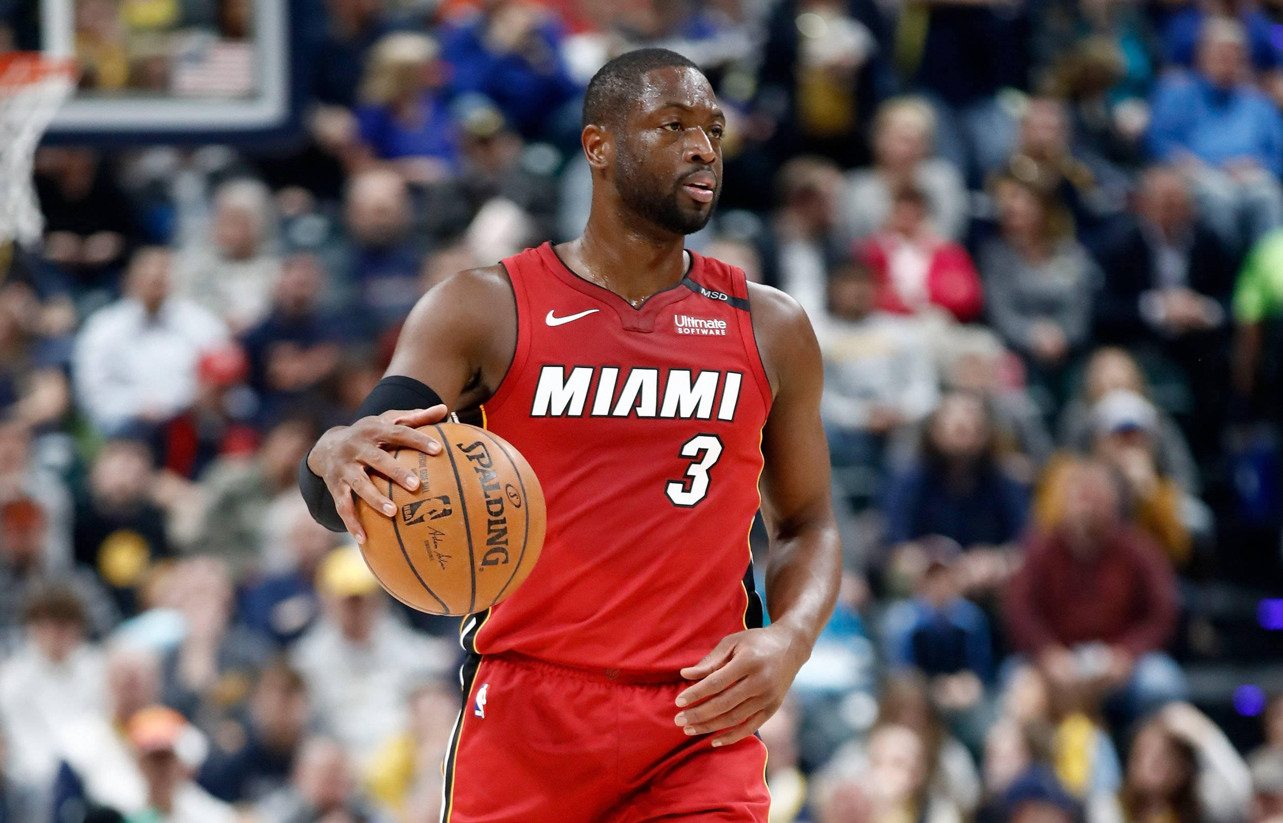 Miami 桌布 壁紙 — 一位身穿紅色3號球衣的邁阿密熱火籃球運動員在激烈的比賽中運球，背景是模糊的人群。