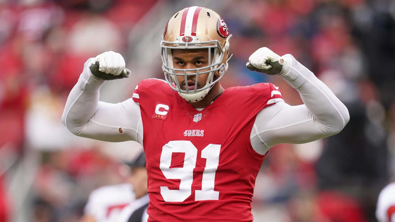 San Francisco 49ers 桌布 壁紙 — 一位身穿紅色91號球衣的舊金山四九人美式足球員在球場人群中彎曲雙臂。