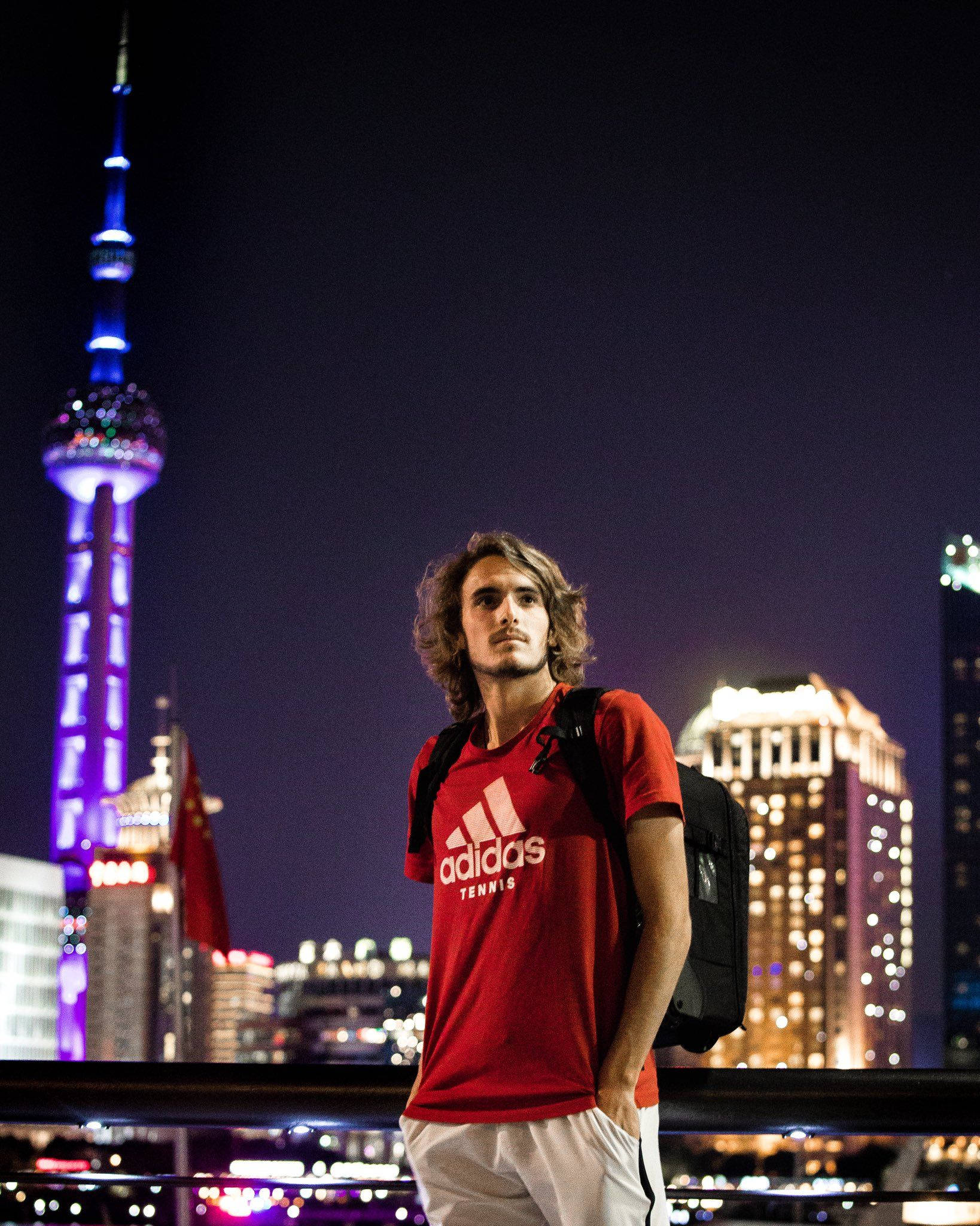 Man 桌布 壁紙 — 一位身穿紅色adidas網球衫的年輕男子自信地站在充滿活力的夜景前，背景是燈火通明的上海中心大廈。