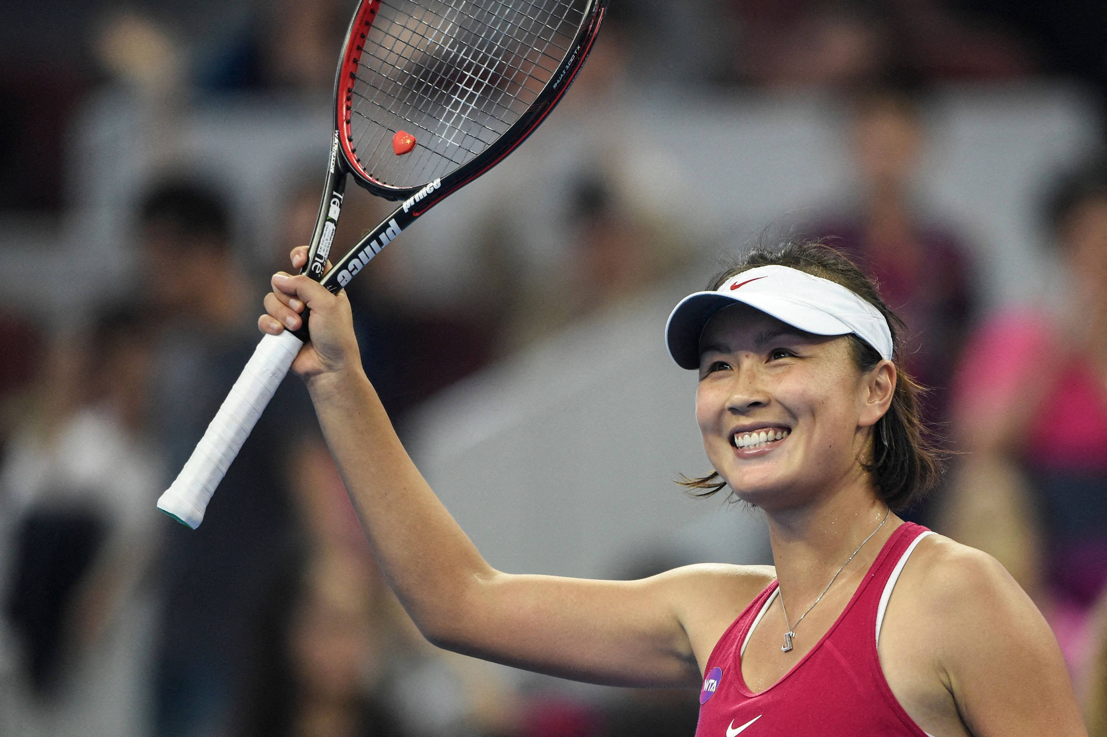 網球 桌布 壁紙 — 一位身穿紅色上衣和白色遮陽帽的女網球選手在比賽後得意地舉起球拍。