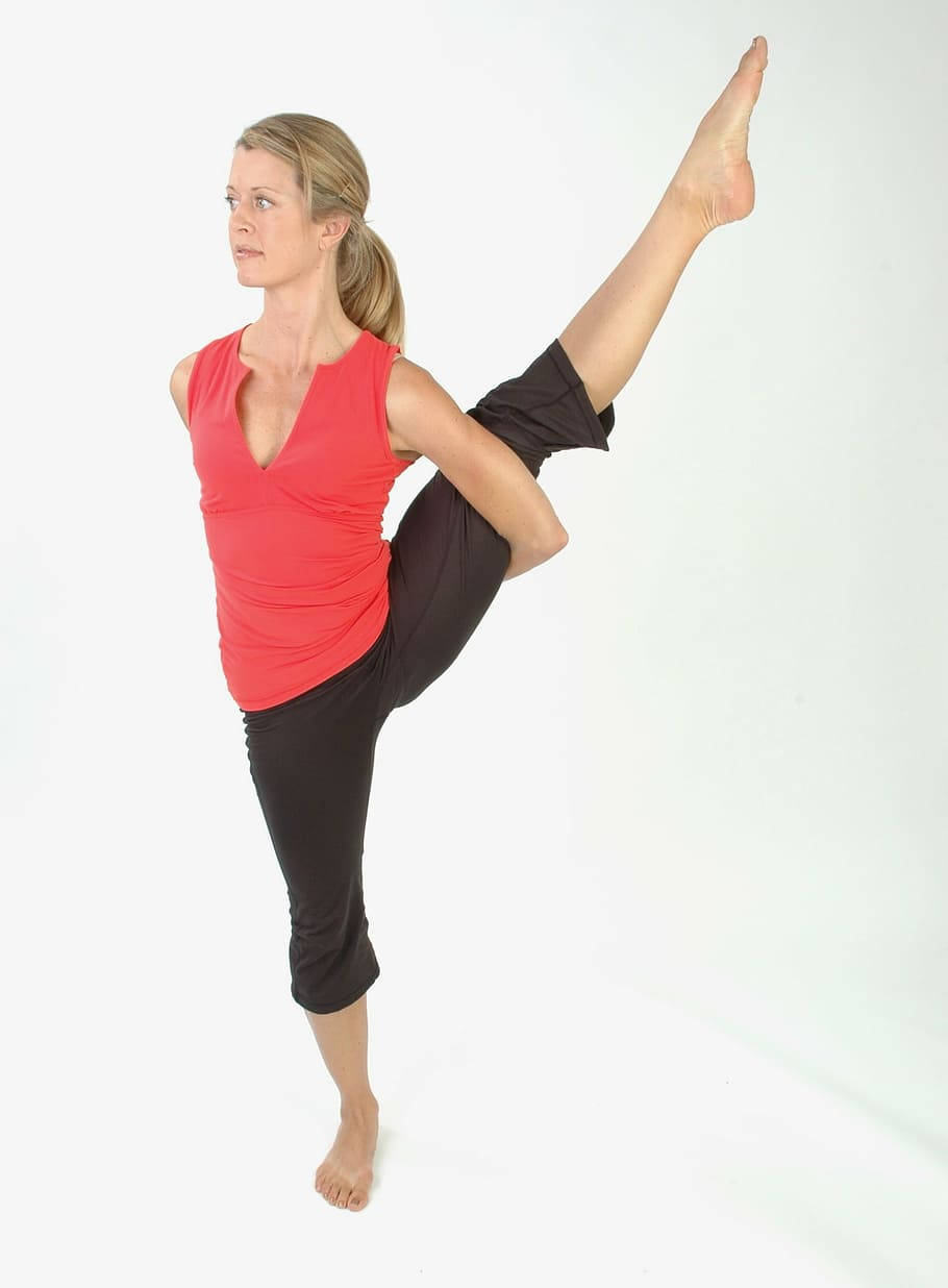 Exercise 桌布 壁紙 — 一位身穿紅色上衣和黑色褲子的女性，在純白色背景上優雅地單腳站立，另一隻腳向上伸展。