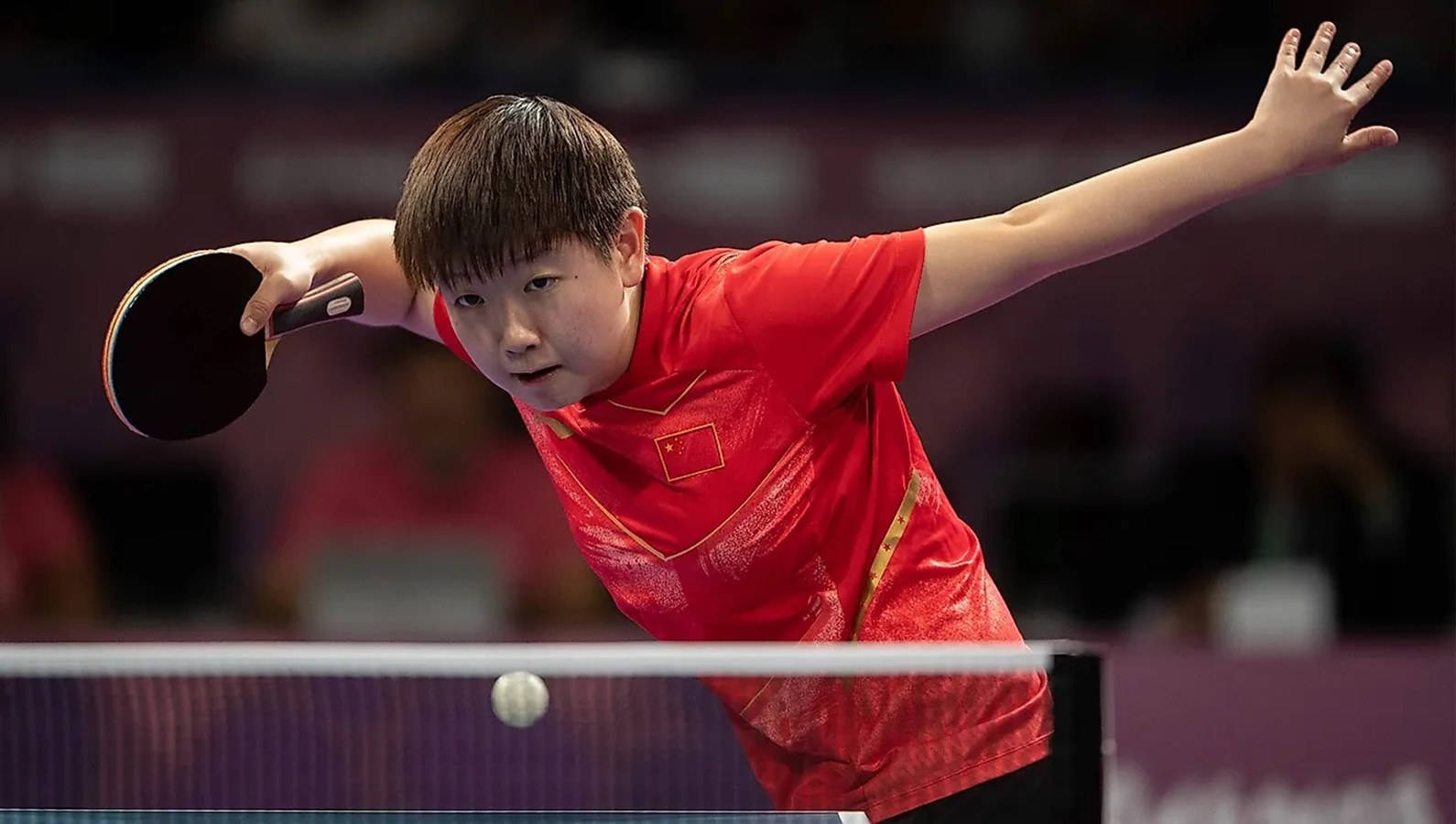 Olympics 桌布 壁紙 — 一位身穿紅色中國隊球衣的專注桌球運動員在激烈的比賽中執行強力的正手擊球。