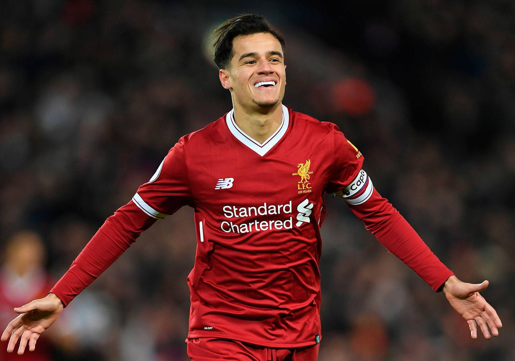 Coutinho 桌布 壁紙 — 一位身穿紅色利物浦球衣的快樂足球運動員在球場燈光下張開雙臂慶祝。
