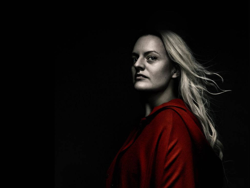Woman 桌布 壁紙 — 一位身穿紅色外套的女性站在黑暗中，風吹動她的金色頭髮，她專注地向前凝視。