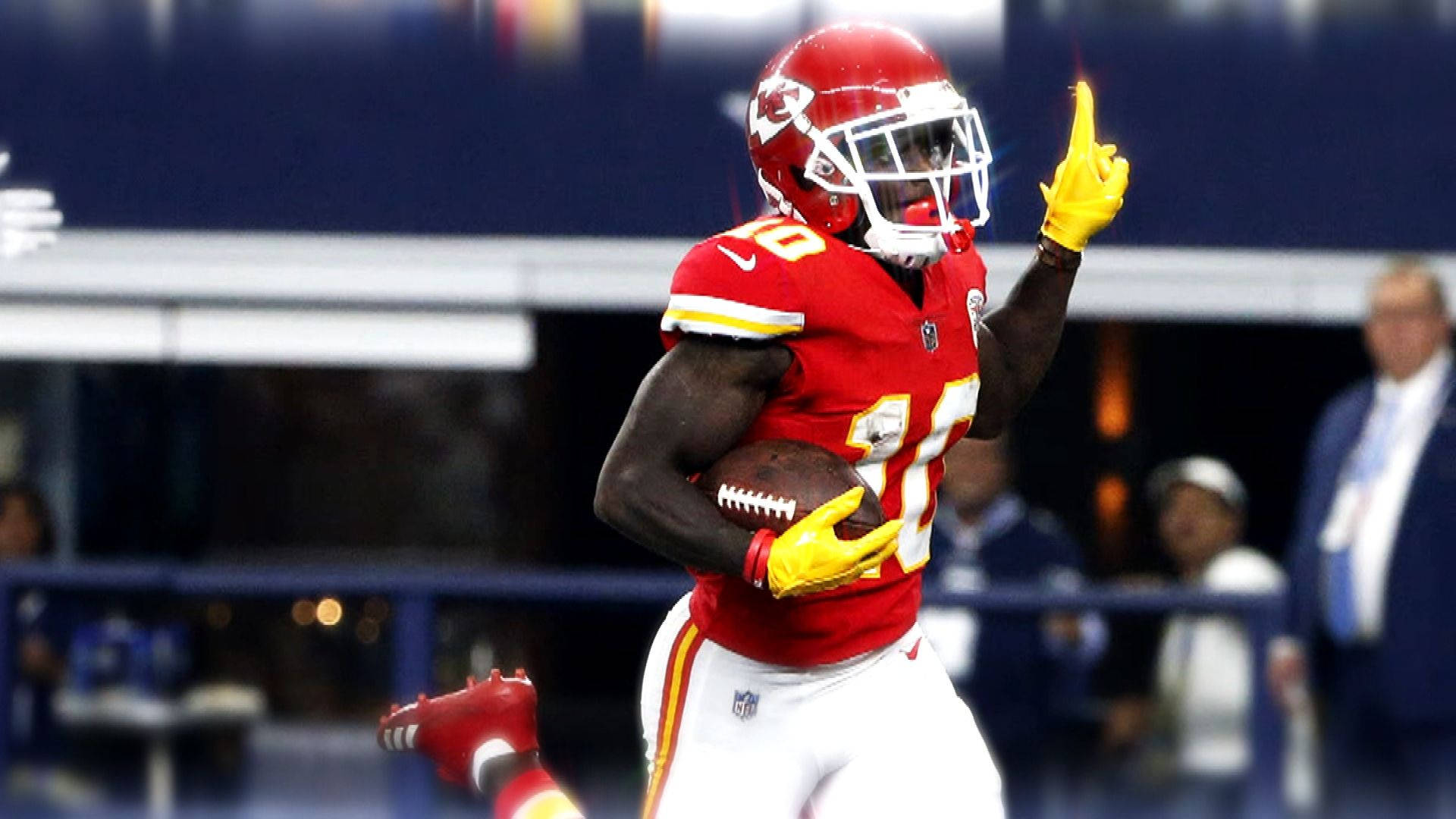 Tyreek Hill 桌布 壁紙 — 一位身穿紅色球衣的堪薩斯城酋長隊美式足球員，舉起一根手指，手持球慶祝達陣。