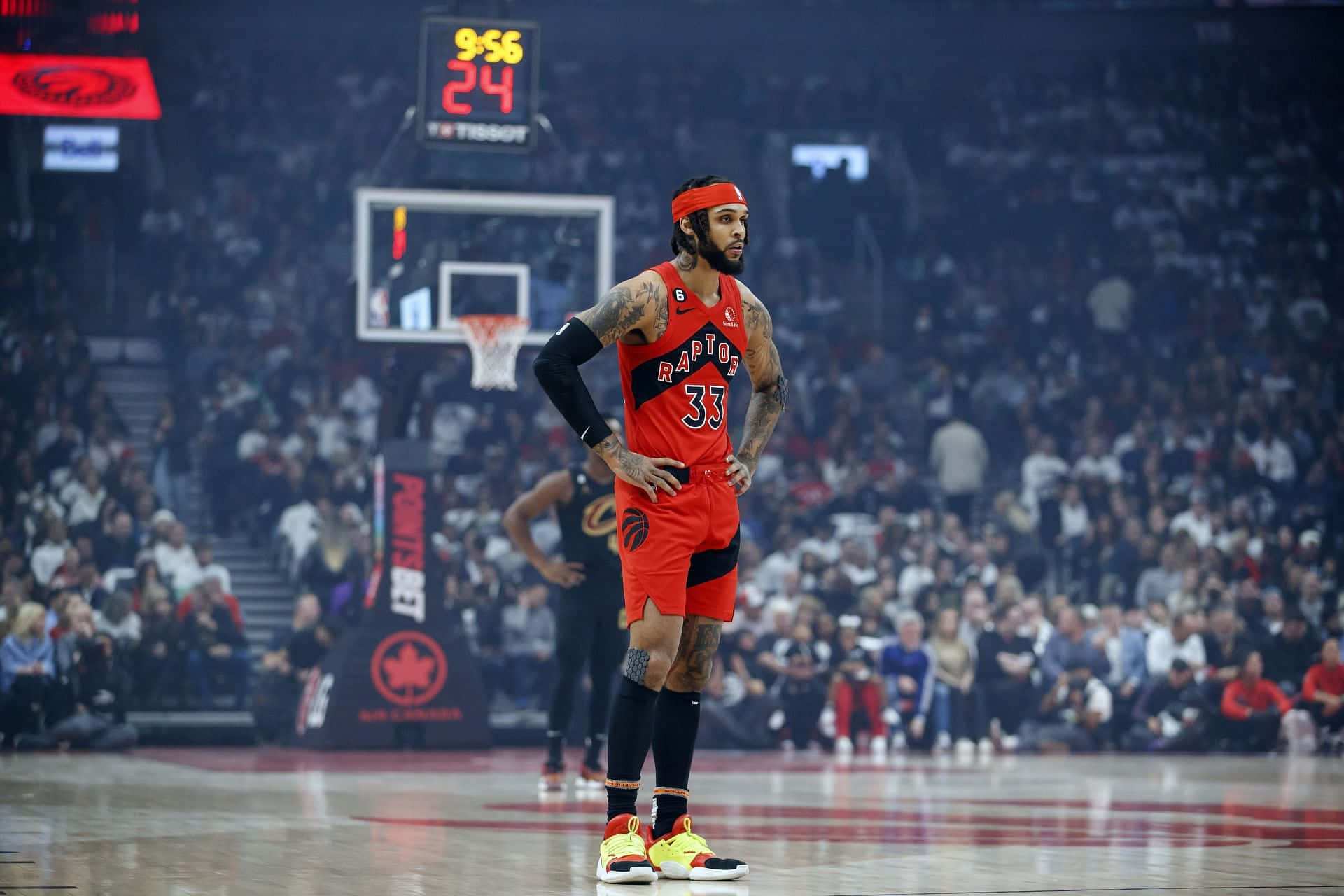 NBA 桌布 壁紙 — 一位身穿紅色球衣的多倫多暴龍隊籃球運動員在場館燈光下雙手叉腰站在球場上。