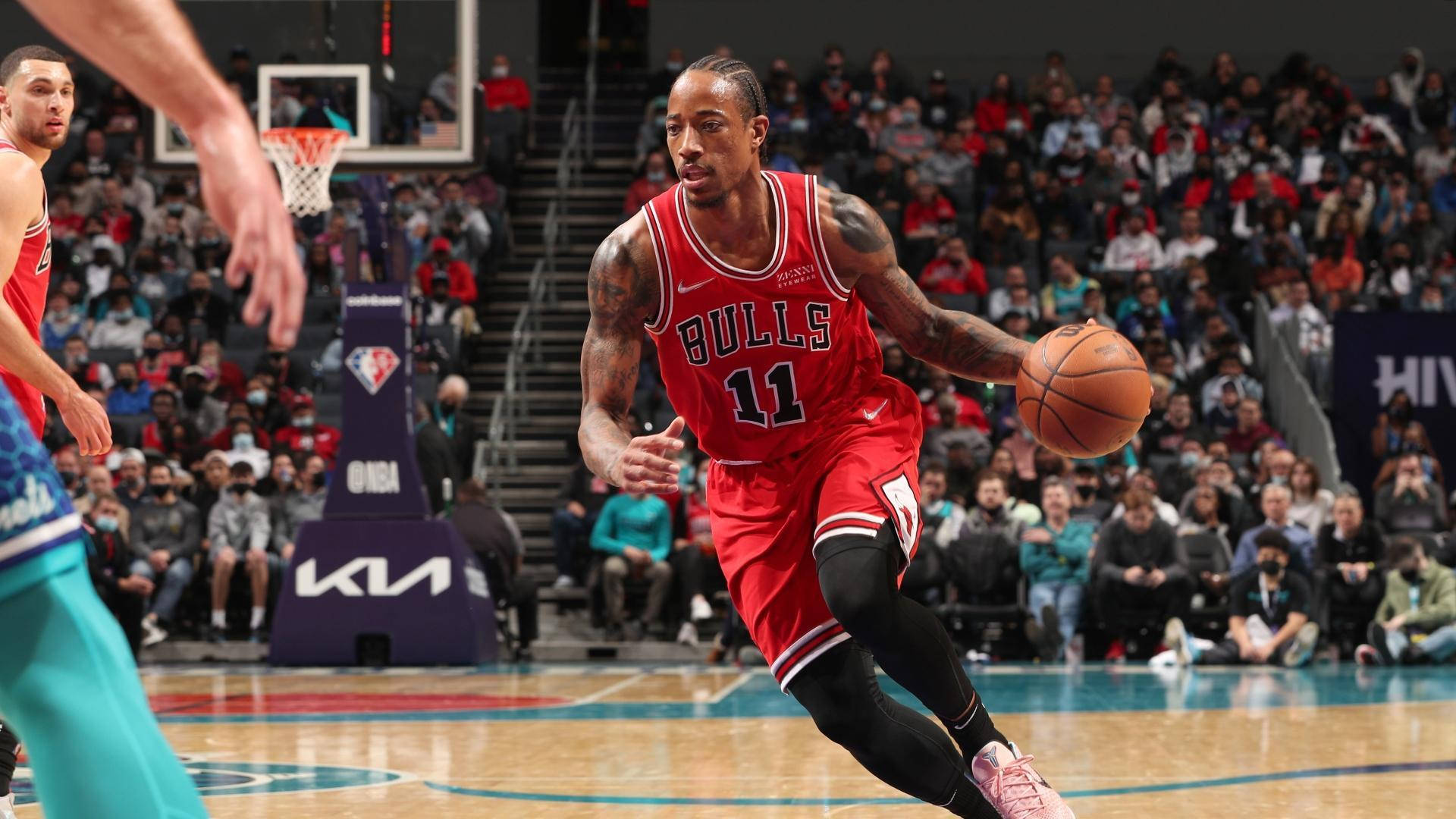 NBA總決賽 桌布 壁紙 — 一位身穿紅色球衣的芝加哥公牛隊球員在激烈的NBA比賽中運球，背景是座無虛席的觀眾。