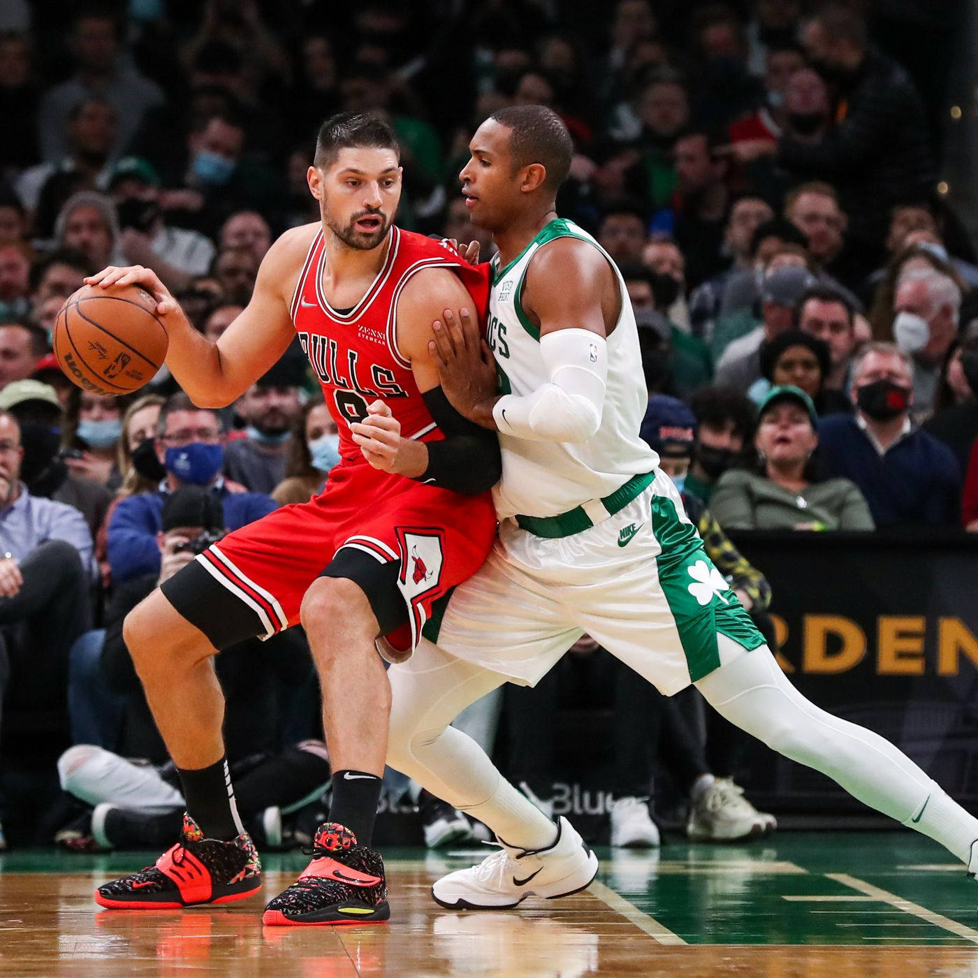 Al Horford 桌布 壁紙 — 一位身穿紅色的芝加哥公牛隊球員正在運球，同時被一位身穿白色和綠色的波士頓塞爾提克隊球員在籃球場上緊密防守。