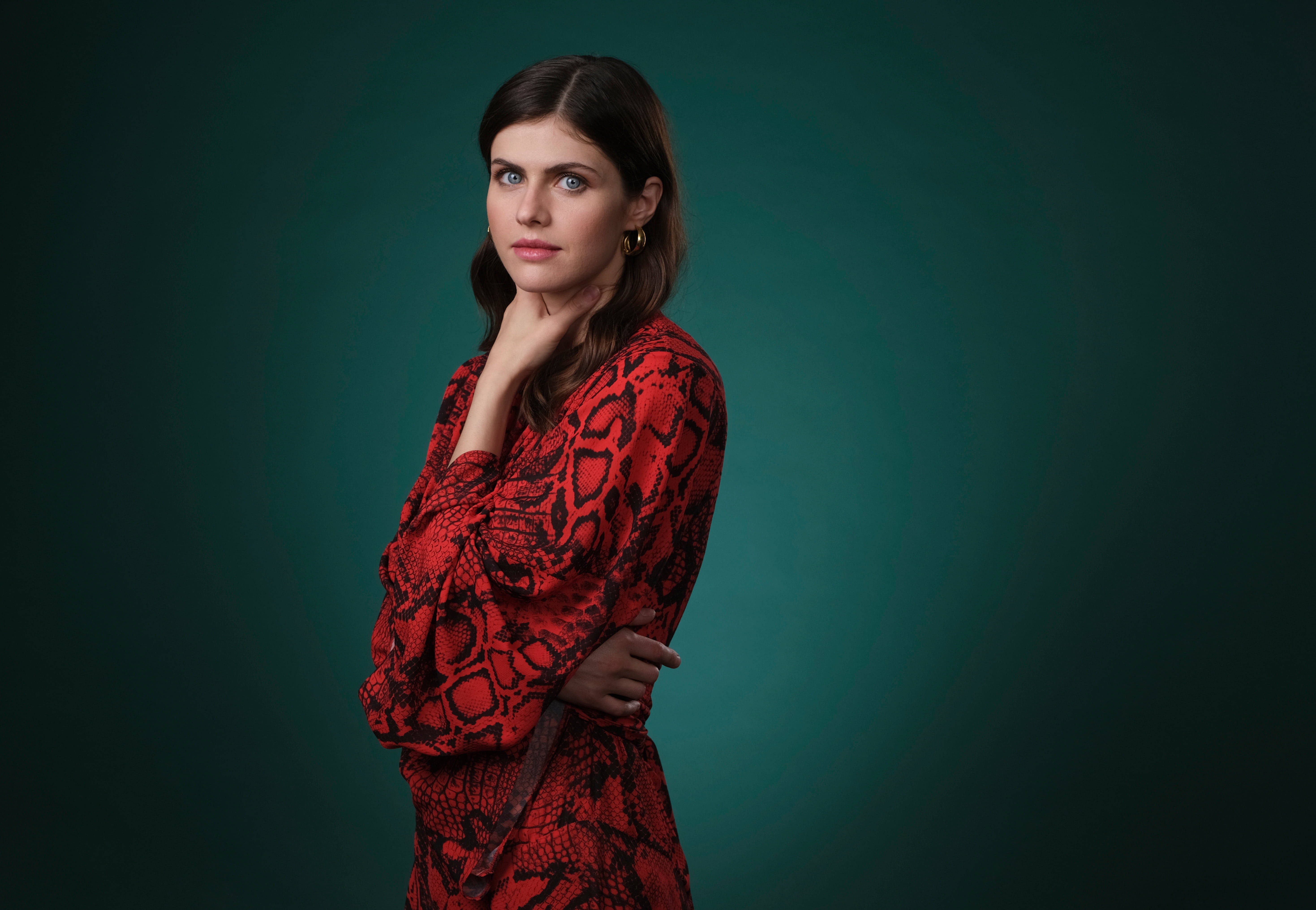 Alexandra 桌布 壁紙 — 一位身穿紅色蛇皮連衣裙的女性在深綠色漸變背景前若有所思地擺姿勢。