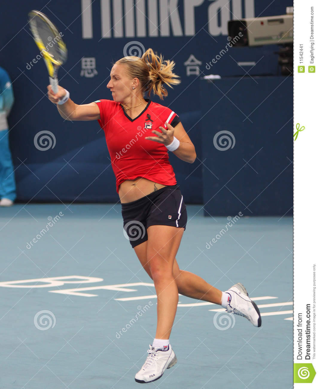 Svetlana Kuznetsova 桌布 壁紙 — 一位身穿紅色襯衫和黑色短褲的女網球選手在藍色球場上揮拍擊球。