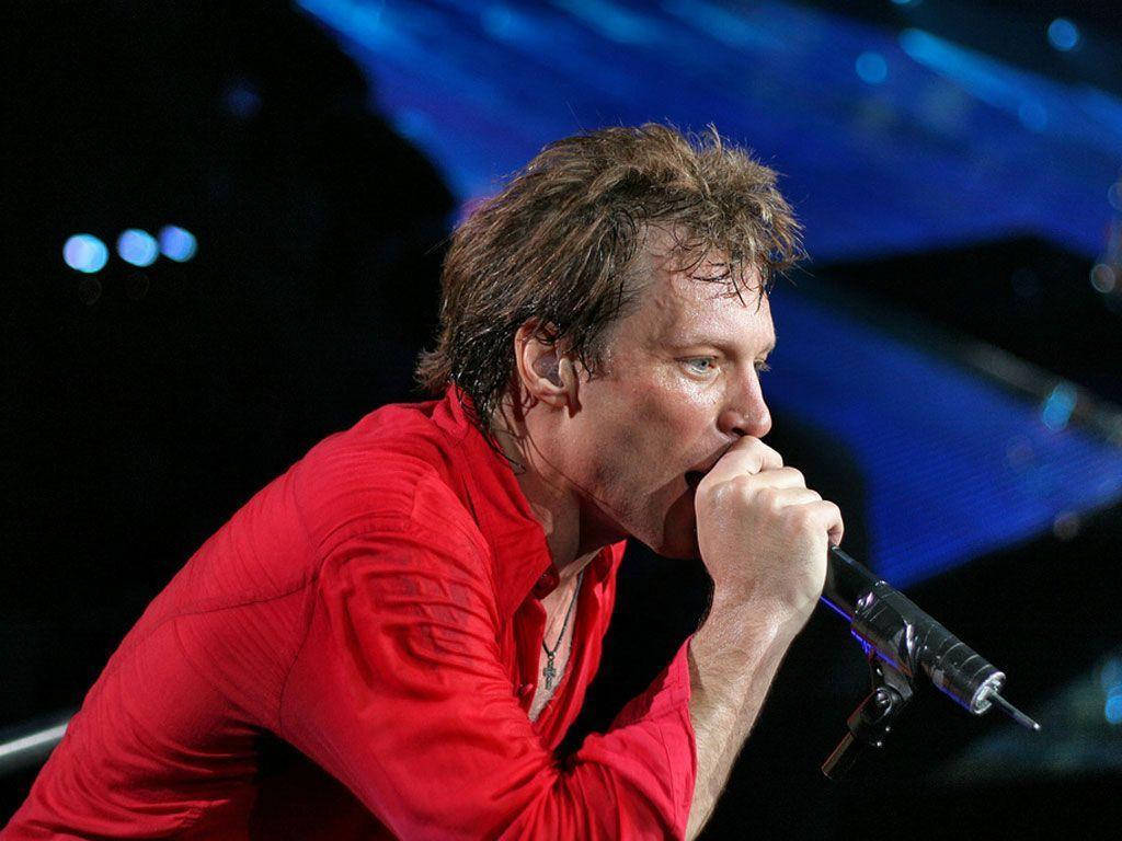 Celebrity 桌布 壁紙 — 一位身穿紅色襯衫的男歌手在藍色舞台燈光下熱情地對著麥克風演唱。