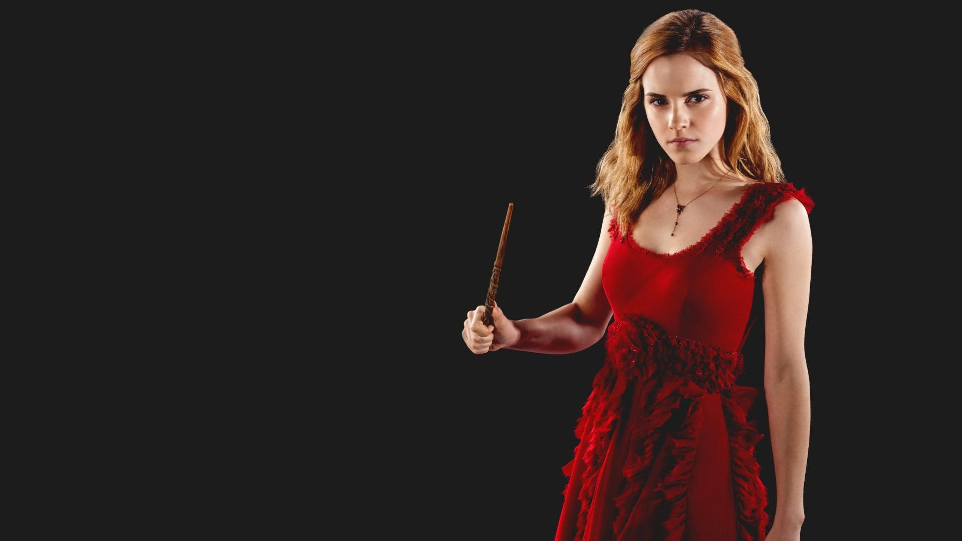 Hermione 桌布 壁紙 — 一位身穿紅色連衣裙的女性，在純黑色背景下，手持魔杖，神情專注。