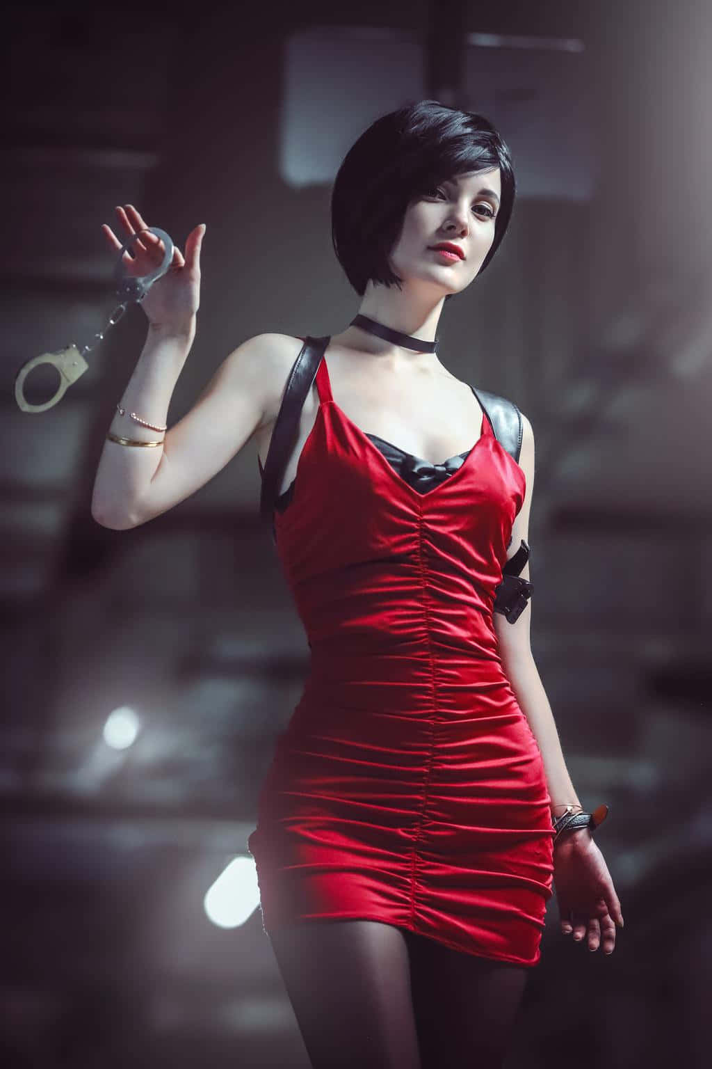 Resident Evil Characters 桌布 壁紙 — 一位身穿紅色連衣裙的女性在光線昏暗的城市環境中，在戲劇性的燈光下拿著手銬。