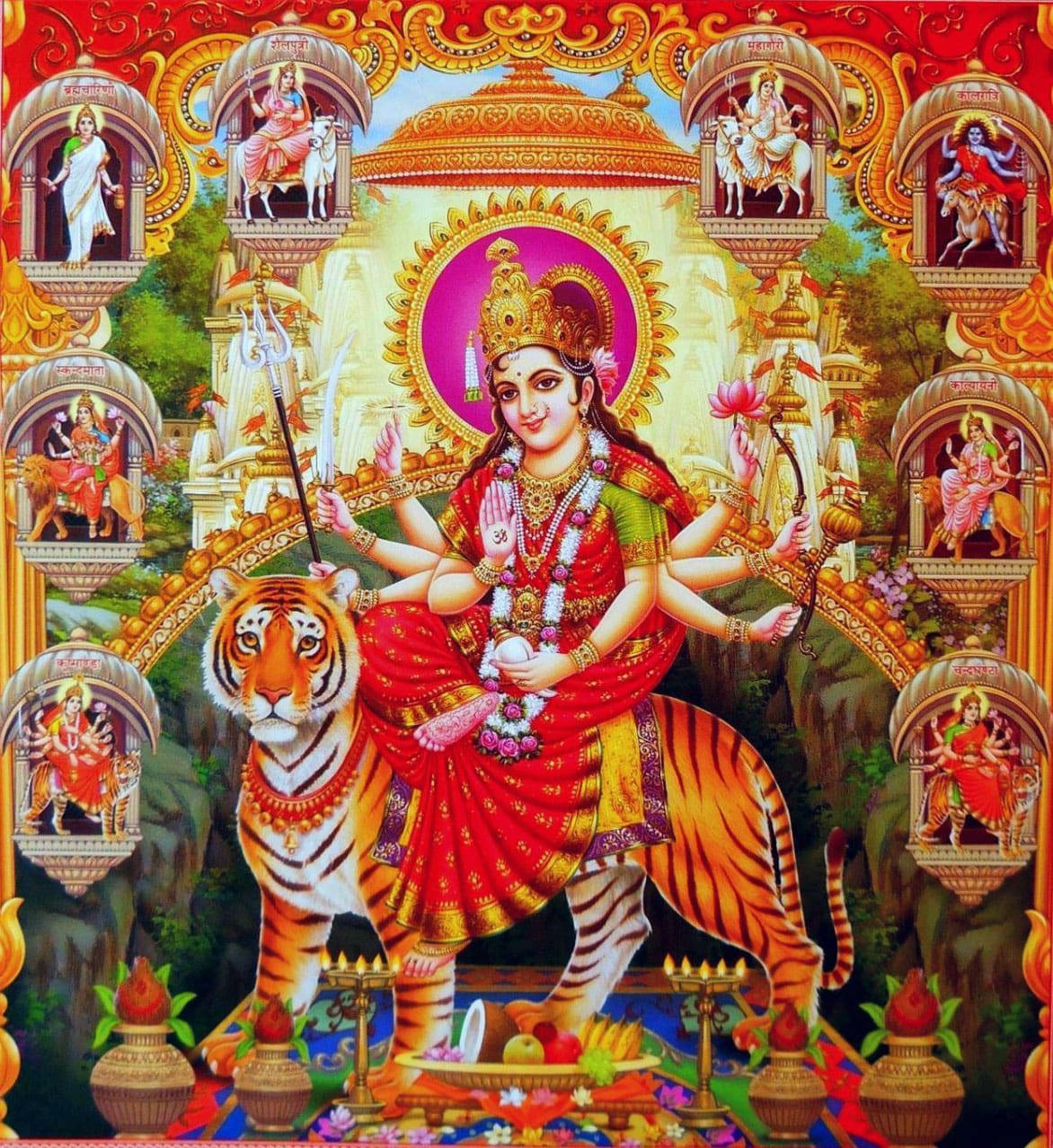 Durga 桌布 壁紙 — 一位身穿紅衣、光芒四射的多臂女神坐在老虎上，周圍是華麗的拱門和神聖人物，構成充滿活力的印度教寺廟場景。