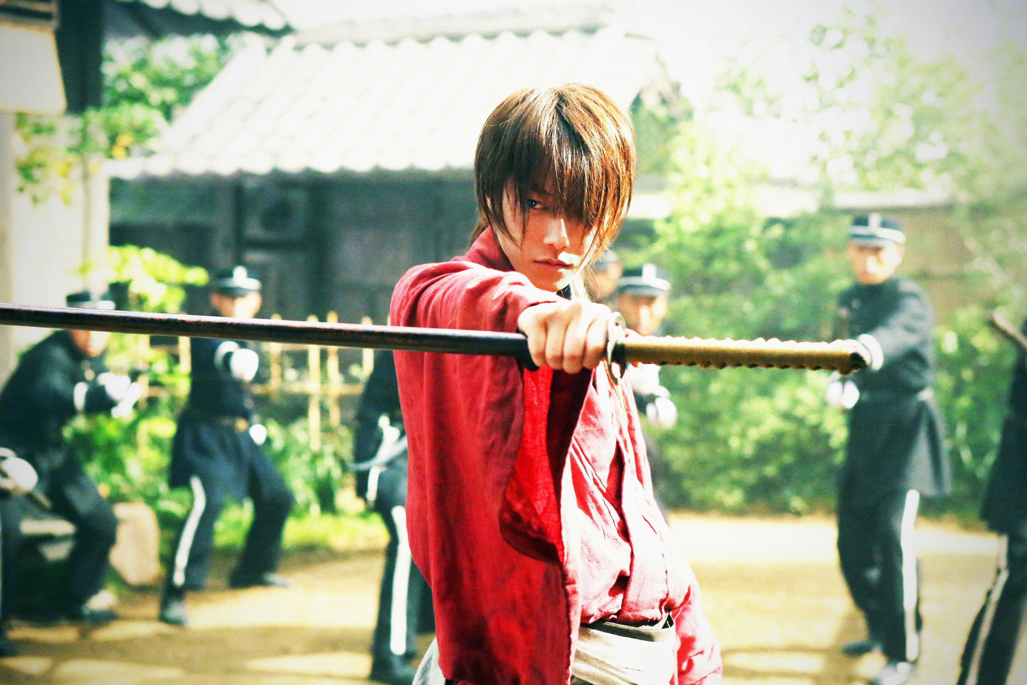 Kenshin 桌布 壁紙 — 一位身穿紅袍的年輕武士緊握武士刀，專注地凝視著，而身穿制服的軍官們在陽光明媚的庭院中保持警覺。
