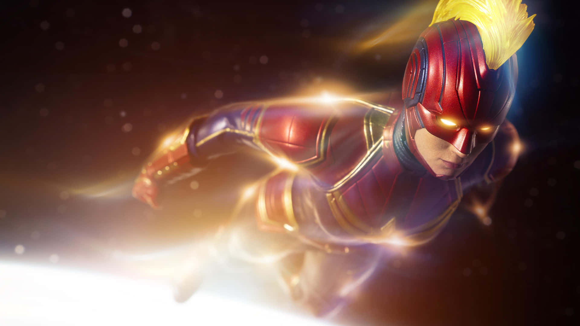 Captain Marvel HD 桌布 壁紙 — 一位身穿紅金盔甲的超級英雄在太空中疾馳，身後留下發光的能量軌跡。