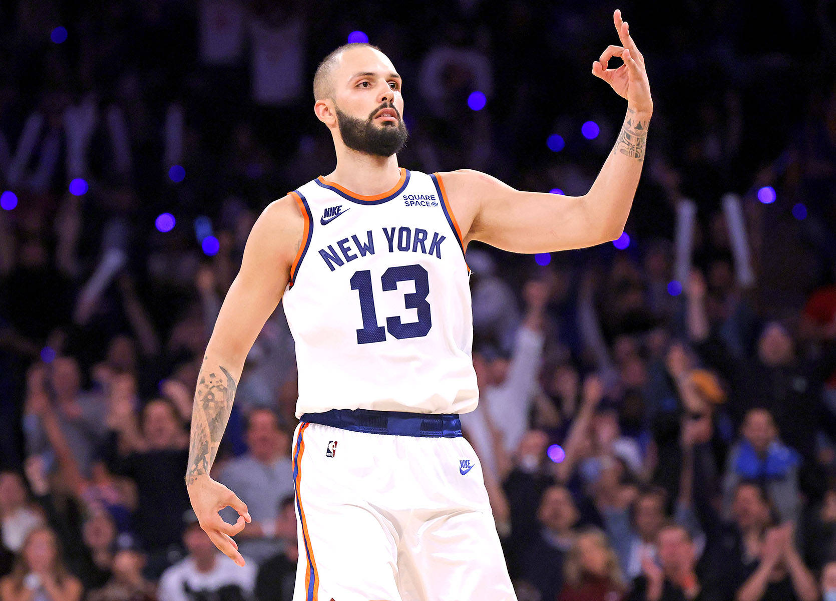 NBA 桌布 壁紙 — 一位身穿紐約尼克隊球衣的籃球運動員在場館燈光下自信地向人群做手勢。