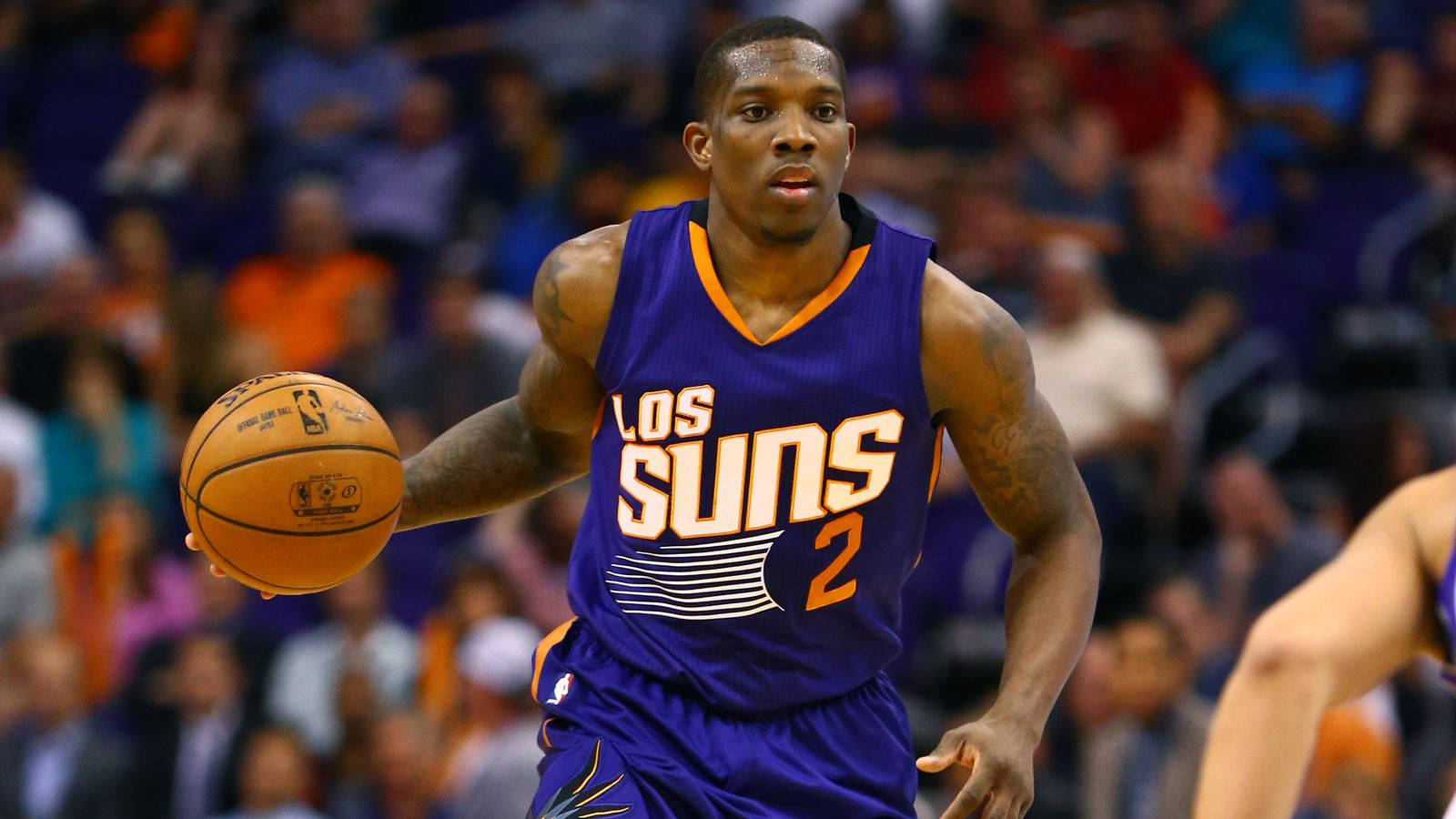 eric bledsoe 桌布 壁紙 — 一位身穿紫色Suns球衣的籃球運動員在激烈的比賽中運球，背景是模糊的人群。