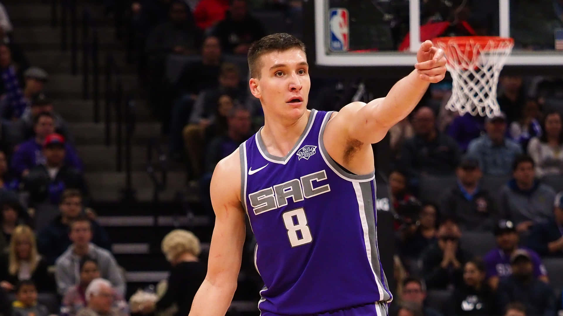 NBA 桌布 壁紙 — 一位身穿紫色沙加緬度國王隊8號球衣的籃球運動員，在比賽中指向籃框，背景有觀眾。