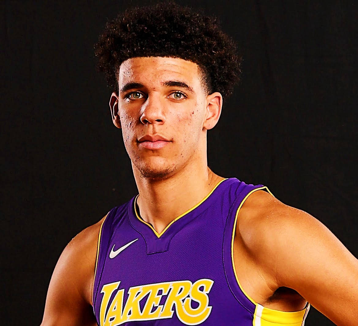 NBA 桌布 壁紙 — 一位身穿紫色湖人球衣的年輕籃球運動員在黑色背景前自信地擺姿勢。
