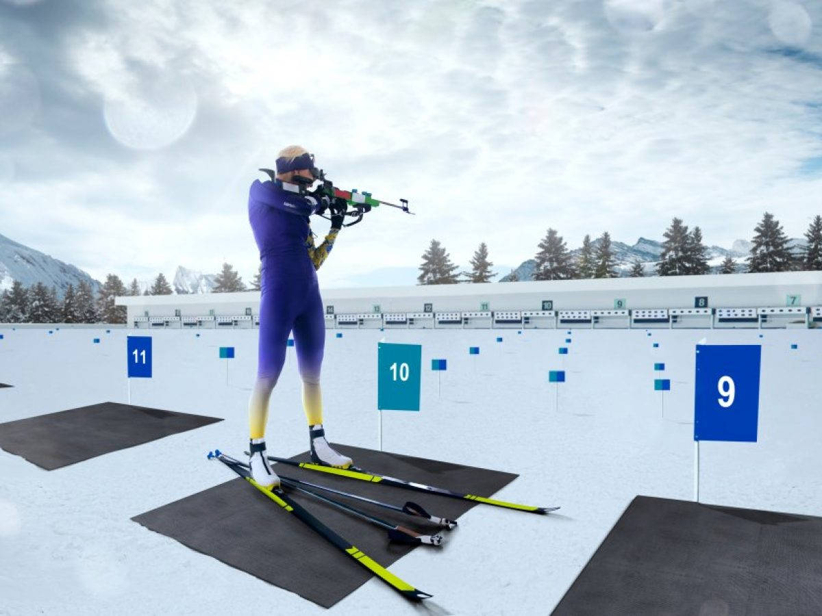 運動 桌布 壁紙 — 一位身穿紫色裝備的冬季兩項運動員在雪地靶場上瞄準目標，背景有山脈和松樹。