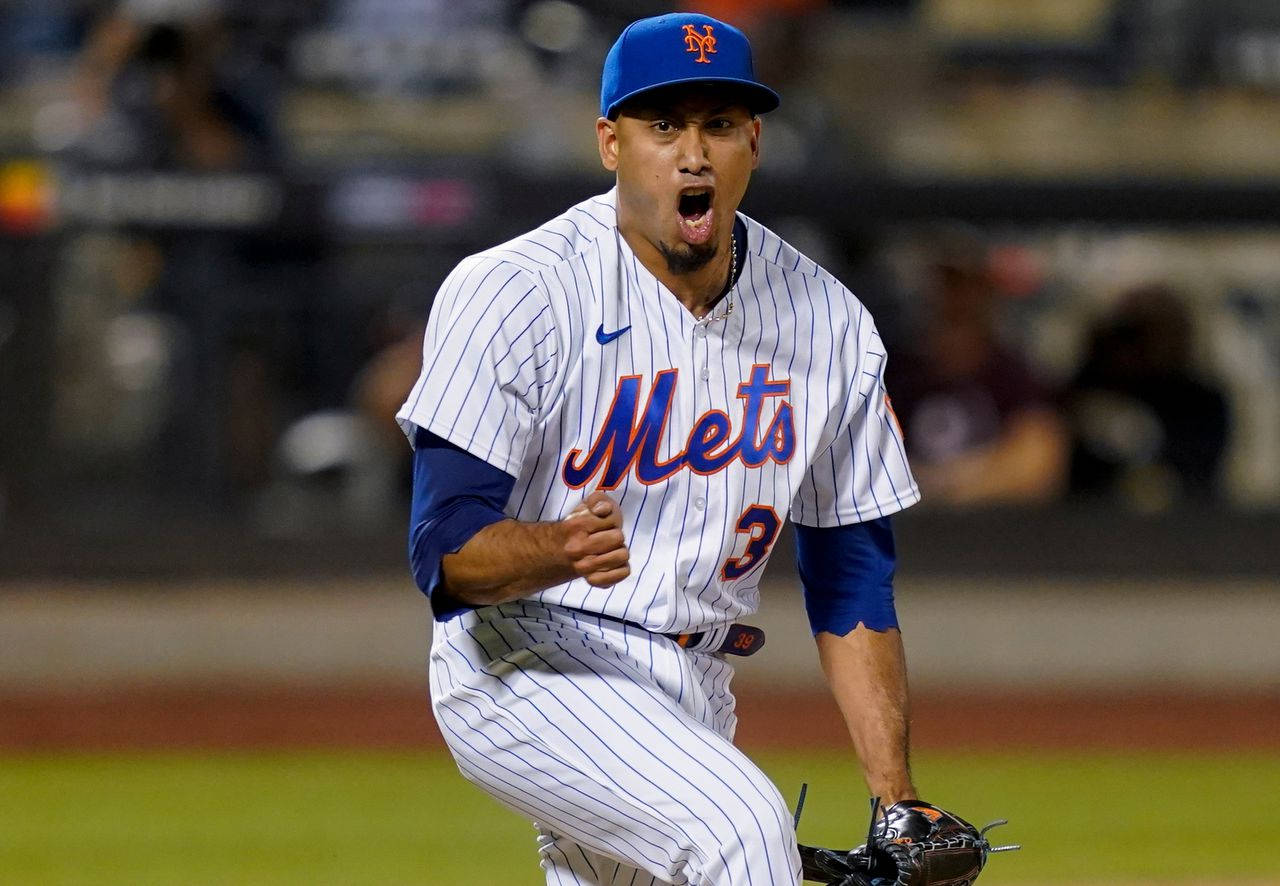 MLB Players 桌布 壁紙 — 一位身穿細條紋球衣的紐約大都會棒球選手在夜間燈光球場上熱情慶祝。