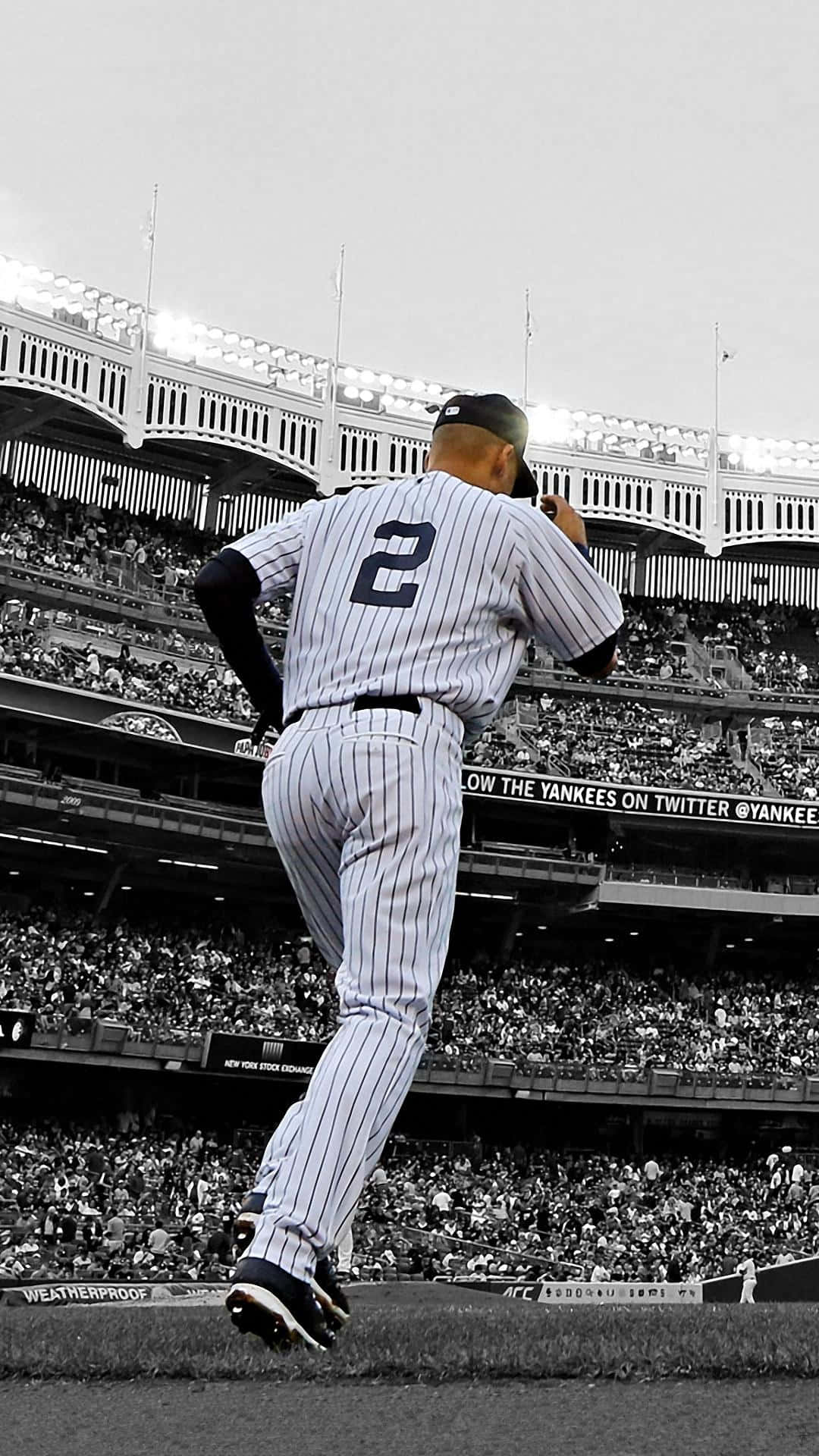 Derek Jeter 桌布 壁紙 — 一位身穿細條紋球衣背號二號的棒球投手，在陽光明媚的球場上準備投球，身後是座無虛席的體育場。