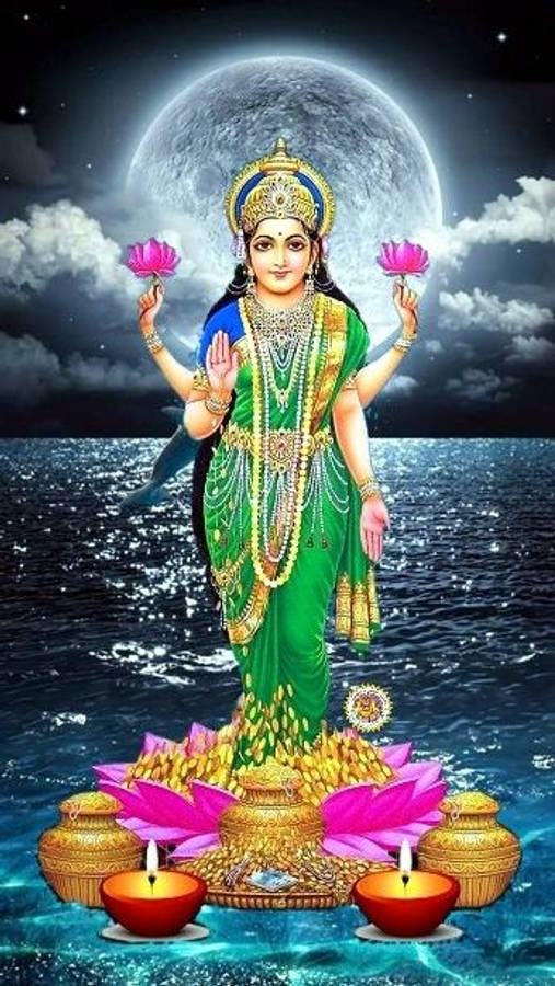 Lakshmi 桌布 壁紙 — 一位身穿綠色和金色的神聖女神站在海洋水域的蓮花上，在滿月下手持粉紅色蓮花。