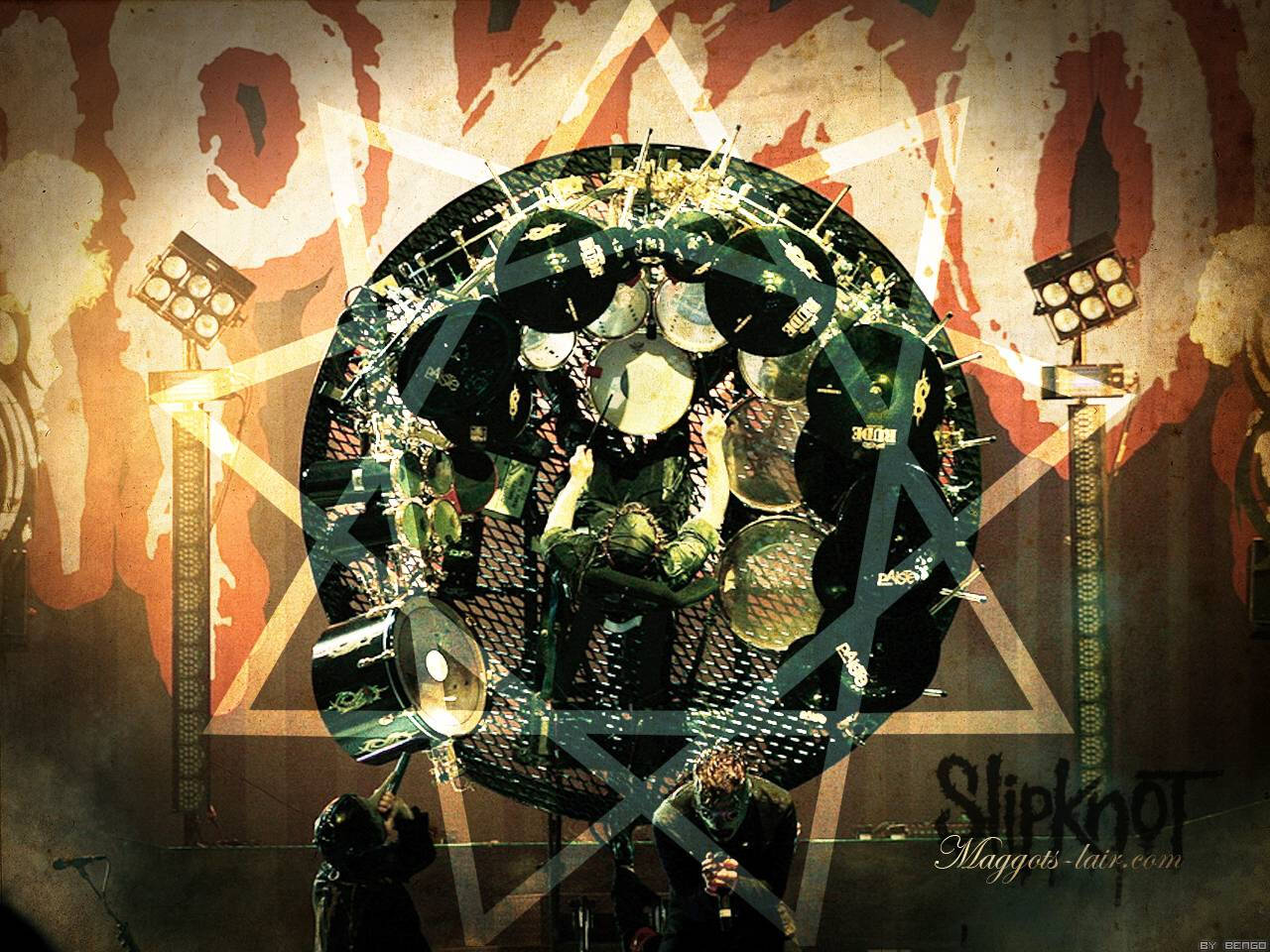 Joey Jordison 桌布 壁紙 — 一位身穿綠色服裝的鼓手在舞台燈光下演奏複雜的鼓組，背景是帶有大星星和樂隊標誌的破舊牆壁。