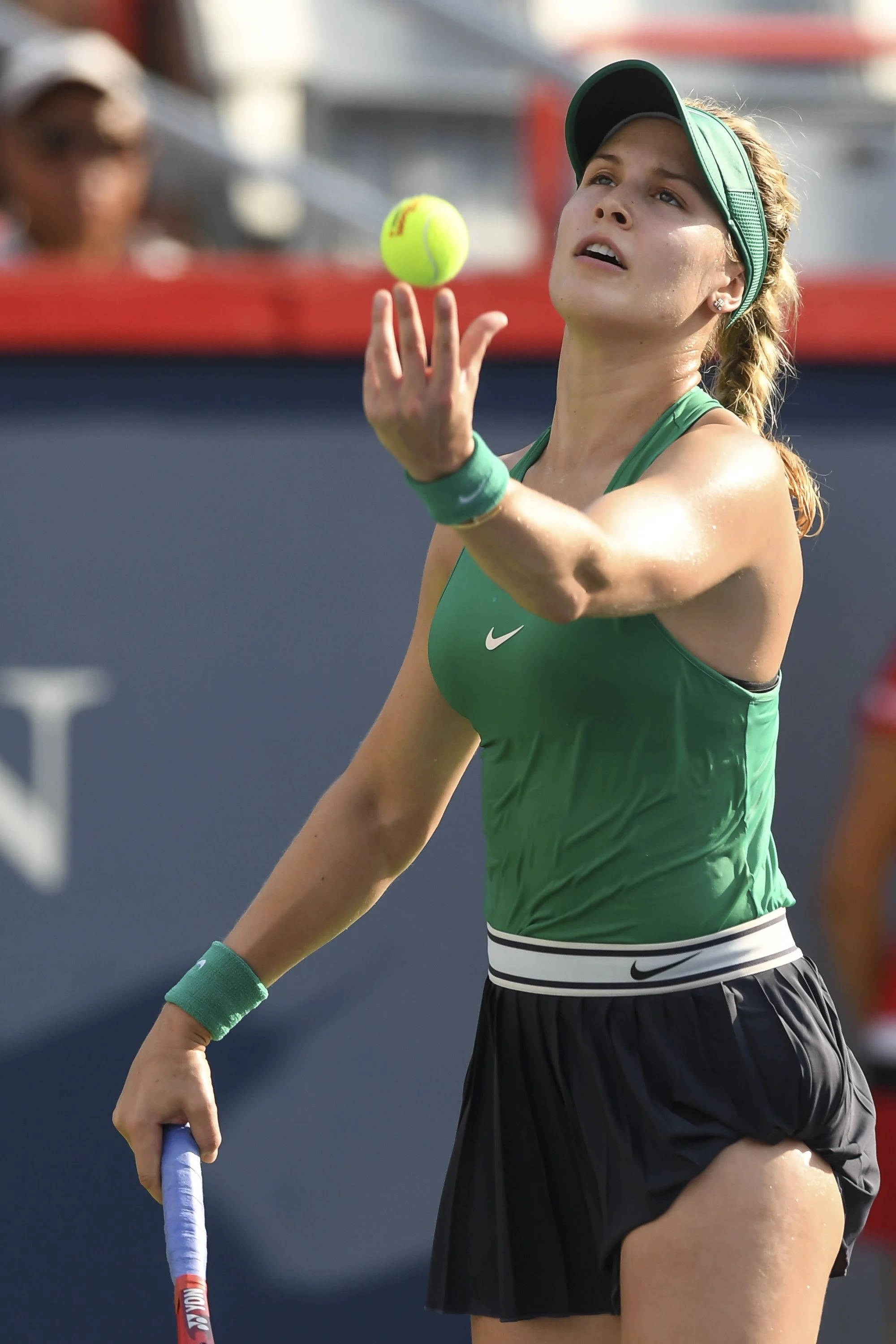 Eugenie Bouchard 桌布 壁紙 — 一位身穿綠色球衣的女網球選手在比賽中專注地將黃色球向上拋起。