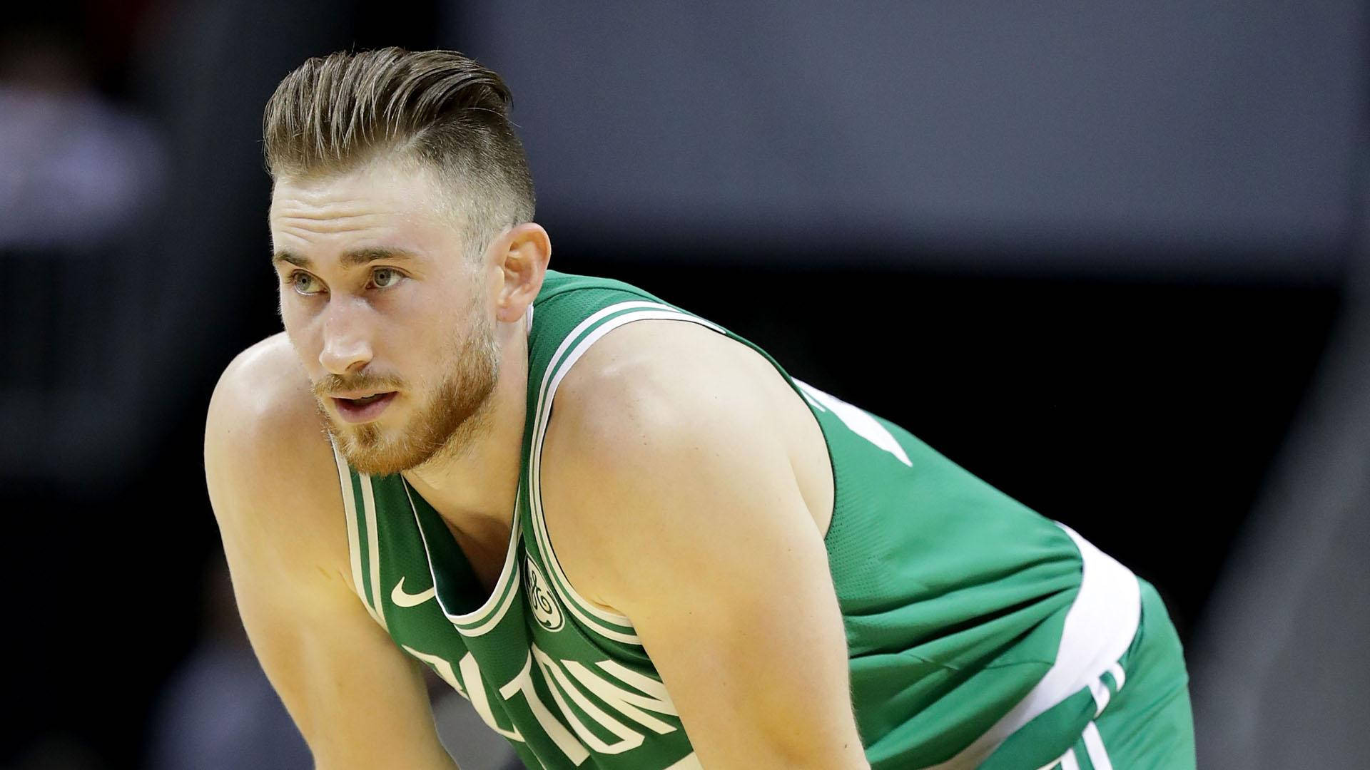 gordon hayward 桌布 壁紙 — 一位身穿綠色球衣的專注籃球運動員在明亮的場館燈光下於比賽中低蹲。