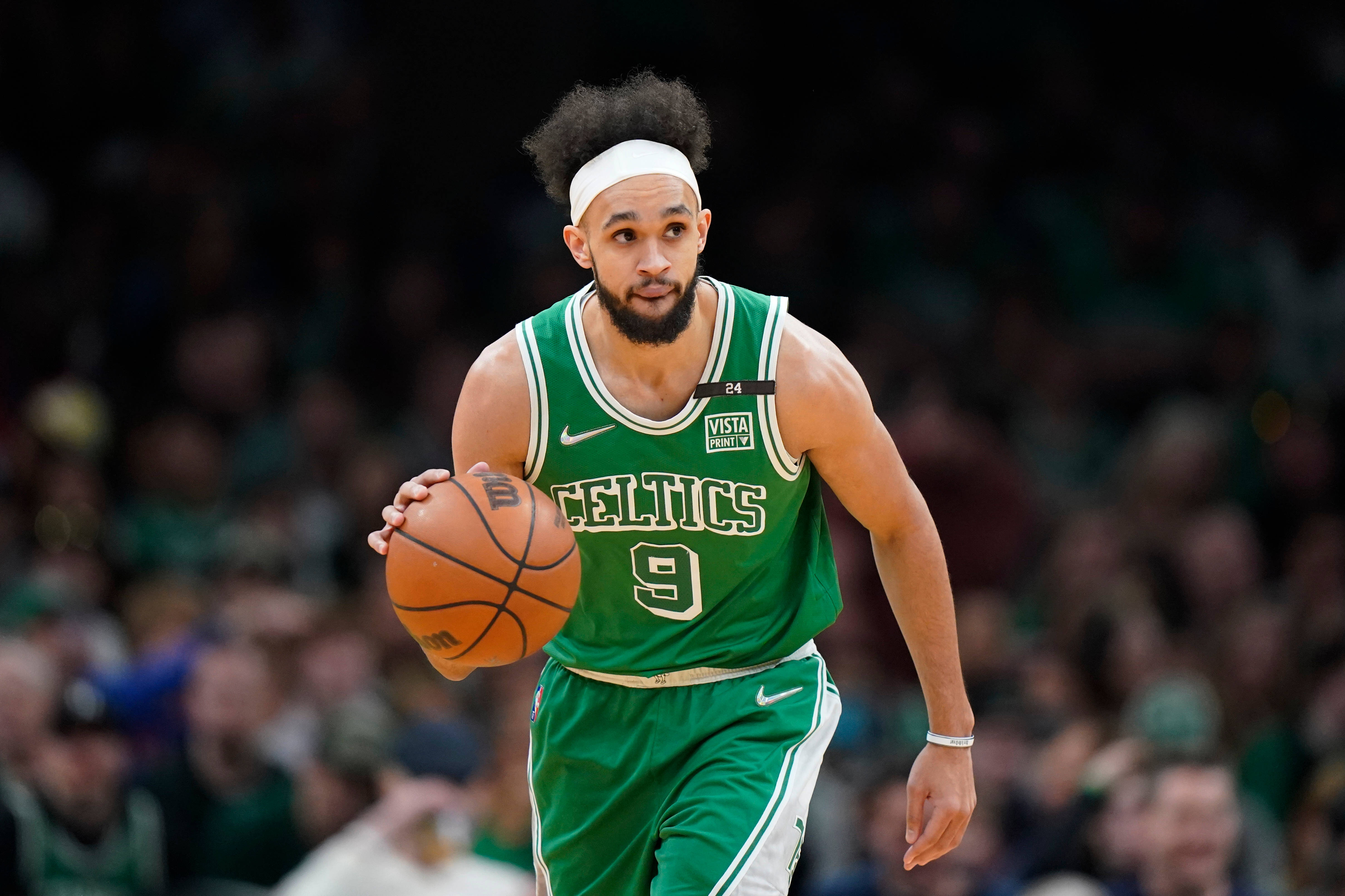 NBA 桌布 壁紙 — 一位身穿綠色球衣的波士頓塞爾提克籃球運動員在比賽中專注地運球。