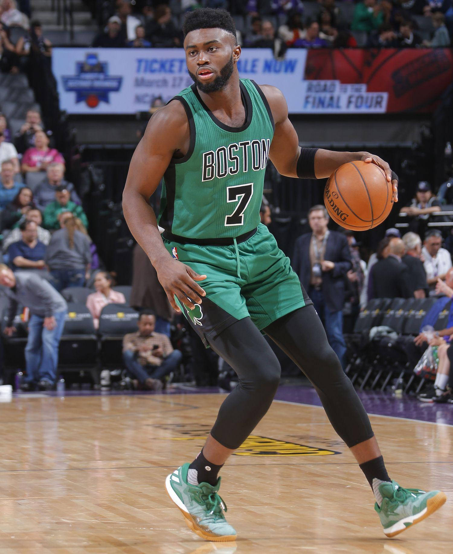 Jaylen Brown 桌布 壁紙 — 一位身穿綠色球衣的波士頓塞爾提克籃球運動員在激烈的比賽中運球，背景有觀眾。
