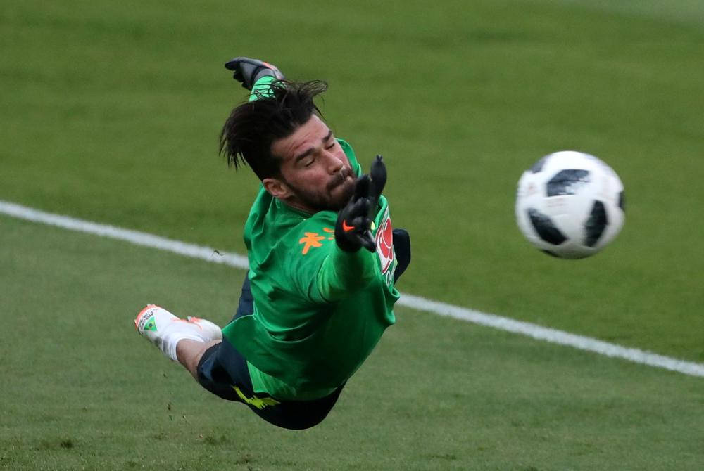 Alisson Becker 桌布 壁紙 — 一位身穿綠色球衣的足球守門員在半空中飛撲，接住草地上的一個黑白足球。