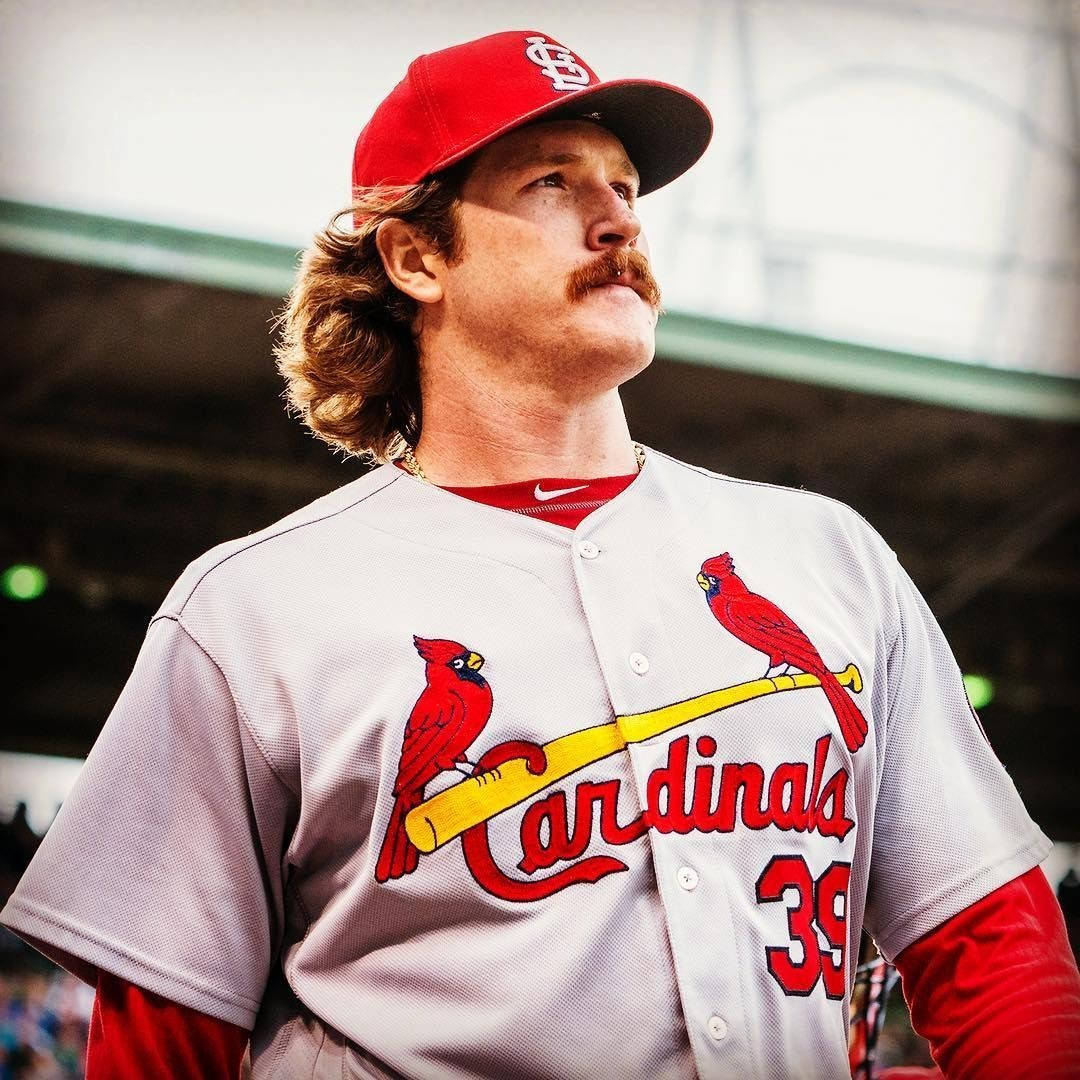 St Louis Cardinals 桌布 壁紙 — 一位身穿聖路易紅雀隊制服、留著鬍子和長髮的棒球運動員在體育館內向上看。