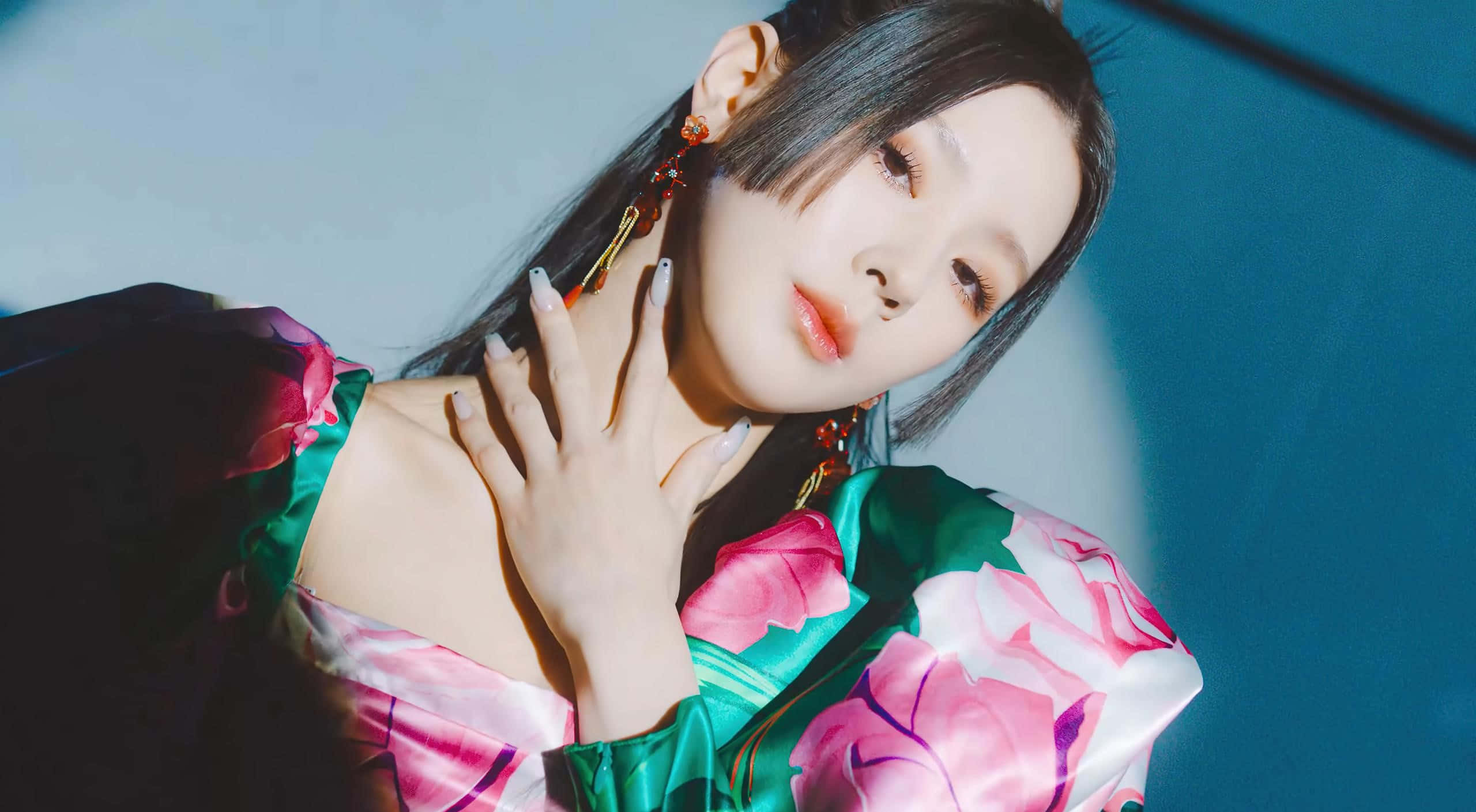 K-pop 桌布 壁紙 — 一位身穿花卉緞面睡袍的女性在戲劇性的藍色燈光下，將手放在脖子上擺姿勢。